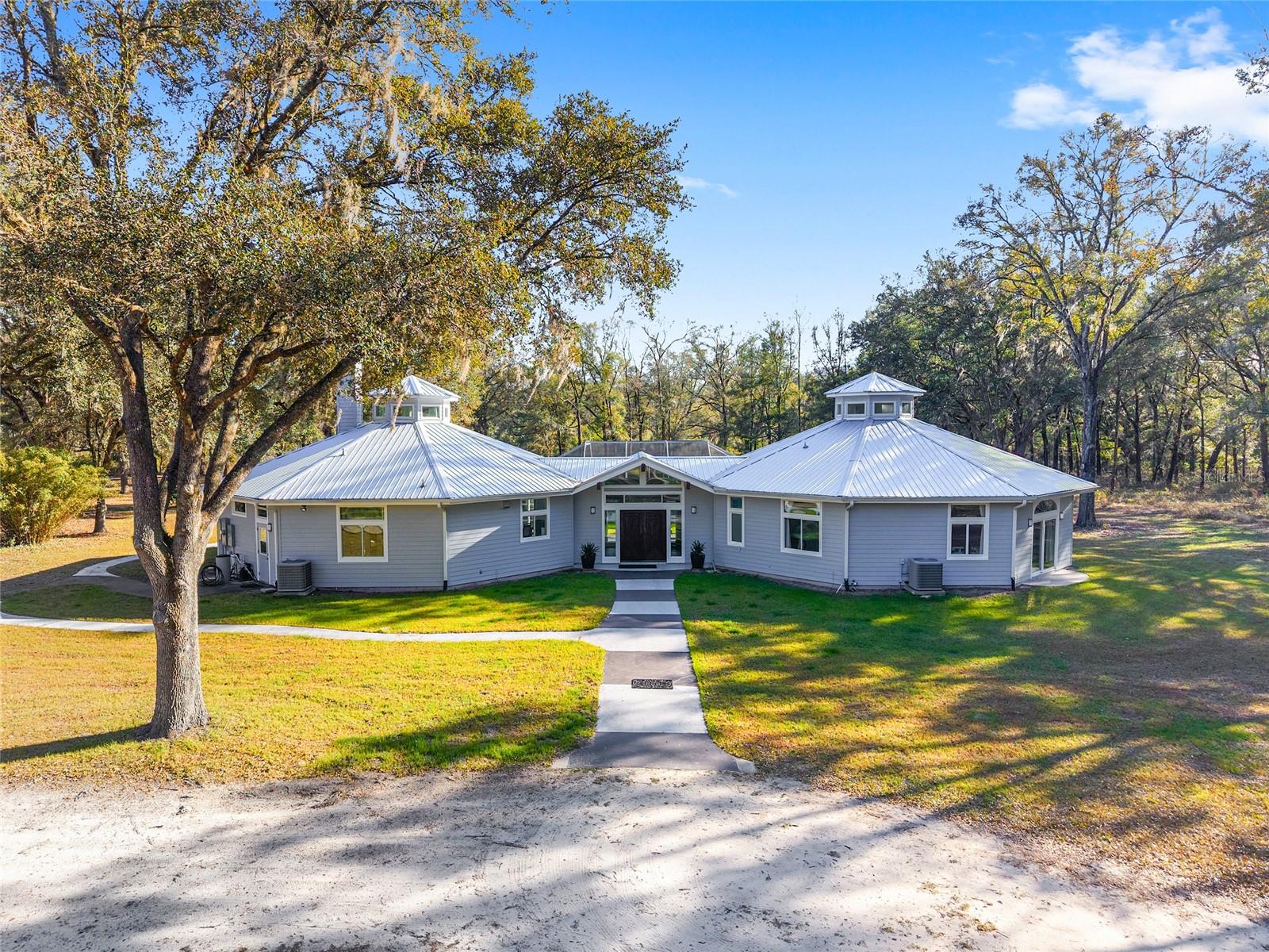Experience the perfect blend of privacy, comfort, and country elegance with this exceptional 5-bedroom, 3-bath estate set on 10.68 acres of fully fenced, park-like land. Majestic oak trees provide natural beauty and seclusion, creating a peaceful setting ideal for equestrian use and farm animals while offering the serenity of true country living.

Tucked away approximately 1.5 miles off the paved road, this property enjoys the quiet of rural surroundings without sacrificing convenience—less than 20 minutes from city amenities, shopping, dining, and recreation. The home itself is thoughtfully positioned near the center of the acreage, allowing scenic views and privacy from every window.

Inside, soaring ceilings elevate the great room, filling the home with natural light and giving the interior a spacious, resort-like atmosphere perfect for both everyday living and entertaining.

The home's layout is both functional and flexible. One bedroom and full bathroom are located in the East wing near the great room, kitchen, and laundry area, thoughtfully separated from the remaining bedrooms in the West wing. This arrangement creates an ideal private guest suite or in-law space, offering comfort and independence while remaining connected to the main living areas.

Extensive upgrades have been completed since 2021, beginning with a fully replaced roof that meets Florida’s updated wind requirements. Additional improvements include a fully insulated garage and workshop combination, a matching storage container, and significant grounds rejuvenation highlighted by a classic four-board fence along the driveway and roadside.

Outdoor living has been enhanced with a screen enclosure and covered patio surrounding the in-ground pool, which has also been converted to a saltwater system for easier maintenance and a more enjoyable swimming experience.

The beautifully updated kitchen features solid wood cabinetry, natural stone countertops, and an impressive suite of high-end appliances from brands including Fulgor Milano, Viking, Bosch, Samsung, LG, and Z-Line. Bathrooms throughout the home have been updated with new vanities and bathtubs, providing modern comfort and style.

Additional features include a Kinetico on-demand water softener system and fiber-optic internet with gigabit speeds available, ensuring both comfort and connectivity.   

Every upgrade and improvement was completed with the intention of making this property the owners’ forever home. A change in circumstances now presents a rare opportunity for you to own one of Central Florida’s most thoughtfully upgraded town-and-country estates, where privacy, quality, and lifestyle come together in a truly remarkable setting.