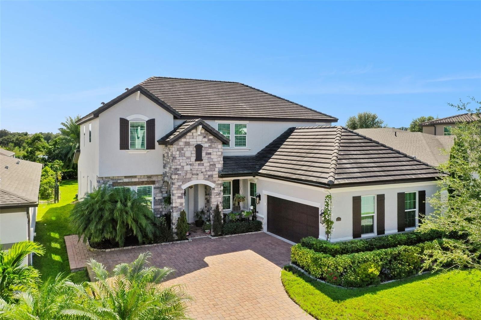 Welcome to this stunning architectural masterpiece nestled in the heart of Twinwaters, one of Winter Garden’s most sought-after communities. This elegant two-story home seamlessly blends sophistication and comfort, offering over 3,600 square feet of beautifully designed living space. Step through the grand entryway to find soaring ceilings, expansive windows that fill the home with natural light, and designer finishes that exude contemporary luxury. The gourmet chef’s kitchen is a true showpiece—featuring 42” custom cabinetry, gleaming quartz countertops, a massive entertainment island, stainless steel appliances, and a walk-in pantry, perfect for culinary enthusiasts and family gatherings alike. The open-concept great room flows effortlessly into a spacious dining area and covered lanai, ideal for both indoor and outdoor entertaining. Upstairs, the luxurious primary suite offers a serene retreat with a spacious walk-in closets, a spa-inspired bathroom with a deep soaking tub, frameless glass shower, and dual vanities. A versatile loft provides additional space for a home theater, gym, or play area, while the first-floor guest suite ensures comfort and privacy for visitors. The private backyard invites you to create your own oasis—whether adding a pool, summer kitchen, or lush garden escape. Enjoy resort-style amenities including a community pool, playground, and picturesque walking trails, all surrounded by pristine lakes and lush landscaping. Twinwaters is ideally situated near Horizon West, top-rated schools, fine dining, boutique shopping, and major highways for an easy commute to downtown Orlando and world-famous attractions. This home truly embodies the ultimate blend of luxury, location, and lifestyle—a rare opportunity to live beautifully in one of Central Florida’s premier communities.