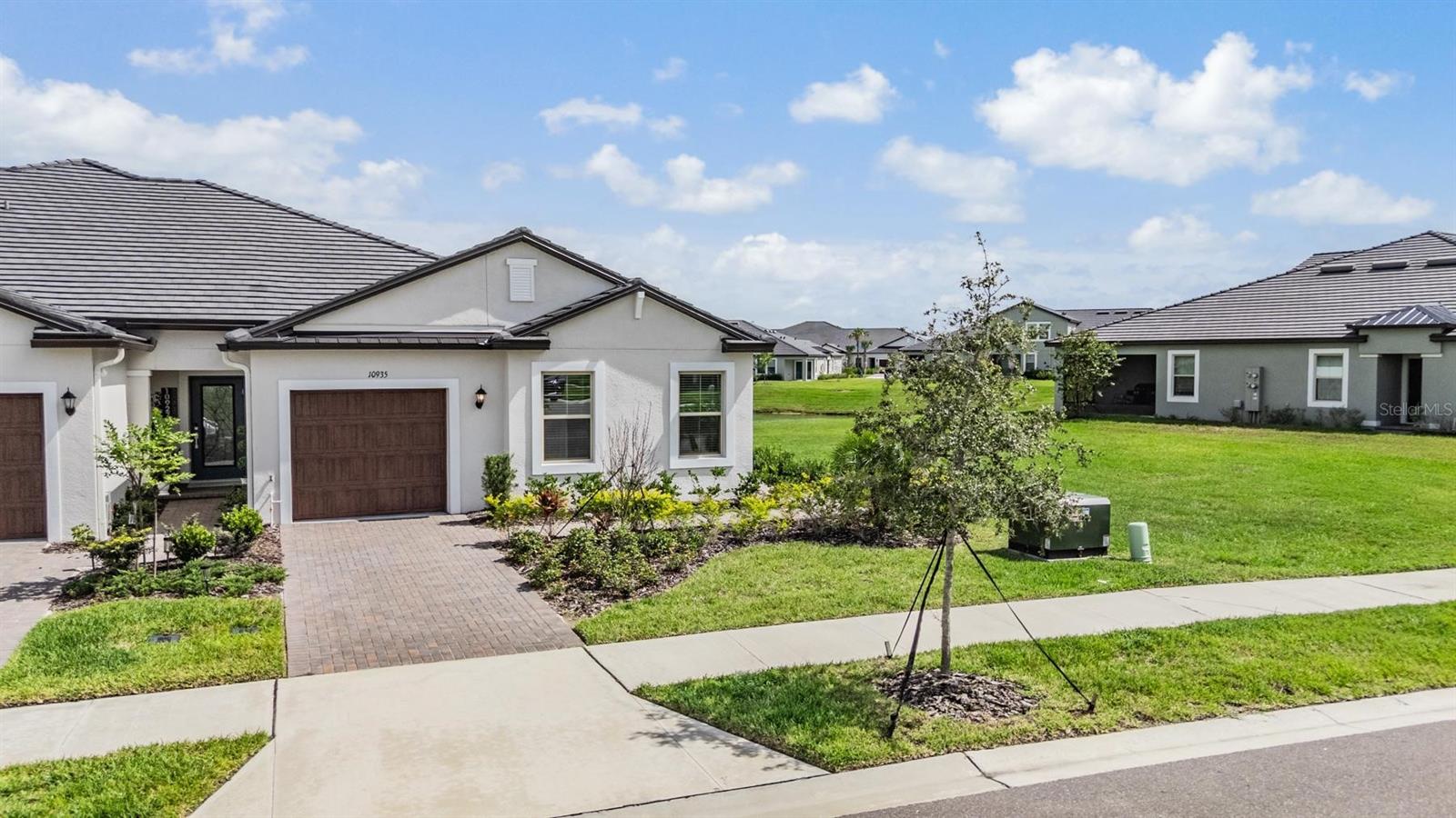 Location, Location, Location! Just steps away from the Clubhouse and Amenity Center! This pristine Pottery Barn inspired Villa with wonderful POND LOT in Medley Active Adult. For those better than 55 years young, presents an exceptional lifestyle just beyond the confines of your home. As a resident, you'll enjoy exclusive Clubhouse access with a full calendar of events daily! You will also enjoy a restaurant & bar, heated pool w/cabanas, ballroom, billiards room, card room, state of the art fitness center, pickleball & tennis courts, bocce ball, yoga, line dancing and private active adult events. PLUS included in your HOA is a 15-acre lagoon membership w/soft, sandy beaches including a swim-up bar, kayaking, paddleboarding, obstacle course, waterslides, corn hole games, and tons of community events! Be sure & invite friends or family to come along with you as you may gift them passes or pay a deeply discounted rate! This immaculate villa will please even the most selective buyers! Comprised of 2 spacious bedrooms, 2 Full Baths + an office/den, and 1 car garage. Your new home includes lots of upgrades including crown molding, quartz countertops throughout, plenty of lighting, stainless appliances and white cabinetry. Sliding glass doors lead to your Lania with a wonderful pond view and extra space between villas. Great spot to sit and relax and enjoy a cup of coffee or glass of wine! As you step inside, you'll be greeted by a seamless flow of open living spaces, making it ideal for both relaxation and entertaining. Get ready to make memories that will last a lifetime! Your dream home awaits; you will be enjoying the CAREFREE FLORIDA RESORT LIFESTYLE in your new home as quickly as you are able to move in! Gorgeous curb appeal on this block villa! Enjoy 42" Cabinets, and Walk-in Pantry in this gorgeous kitchen. Primary Suite includes ensuite bath, dual sinks, and Walk-in Closet to keep you organized, and ceiling fans to keep you cool. High-speed (ULTRAFI) internet, premium cable, yard maintenance & exterior painting and homeowners' insurance for structure are covered by HOA. The location of this residence is equally remarkable, situated in close proximity to premier shopping destinations, and an array of dining options, you'll find yourself immersed in a vibrant community that strikes a perfect balance between exclusivity and convenience. Ride your Golf Cart to the Clubhouse, Publix, restaurants, Farmers Market, Chick-fil-A, Banks, Starbucks, Nail Shops, and more! Close to Advent Health Hospitals, BayCare Hospital, Florida Medical Clinic, Wire Grass Mall, Tampa Premium Outlet Mall, Krate at the Grove, Sam's Club, Costco, Golf Courses & Movie Theater. Easy access to I75, 275,