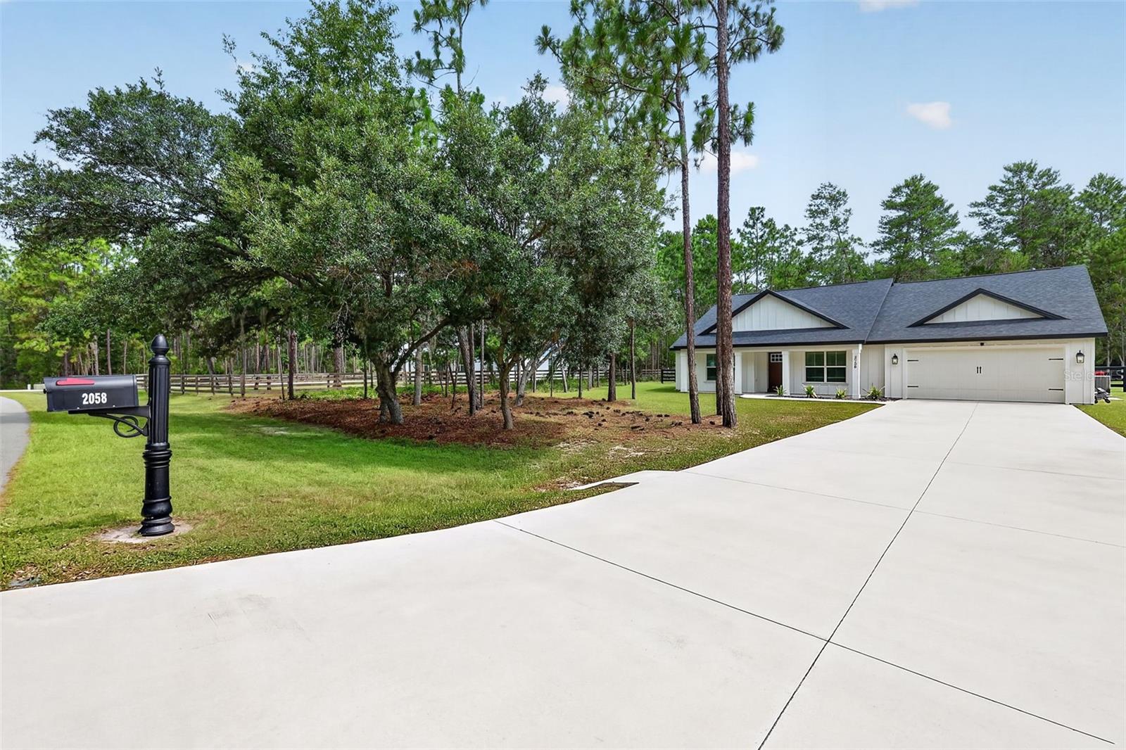 Welcome to your dream home in the highly sought-after Oak Hill subdivision in Wildwood, Florida.  This superior quality, newer build, sits on over an acre of beautifully landscaped land. Inside, you’ll find three well -proportioned bedrooms and two luxurious baths, along with a den/office space separated by a stylish barn door, perfect for a private workspace or creative retreat.  Enjoy a spacious game room with built-in cabinetry offering plenty of storage for games and media, creating the ideal space for entertainment or family fun.  A convenient laundry room also offers built-in cabinetry ensuring organization and ease. Flowing seamlessly from the living spaces, the home features a custom kitchen boasting café appliances, a unique custom hood vent, and a microwave drawer in the island.  The kitchen also features stunning Cambria Quartz countertops complemented by 42-inch cabinetry with soft-close doors and drawers completing this exceptional home.  Relax by the elegant electric fireplace with a brick-look paver hearth, a floating mantle, and shiplap accents above.  The dormers, along with the beautiful board and batten Hardie Board exterior, add both character and curb appeal to the home.  Step outside to enjoy a backyard oasis, where a four-board wood fence encloses the space, providing privacy and a perfect setting to relax, entertain, and enjoy the serenity of this exquisite home. All in a serene, coveted location—don’t miss your chance!