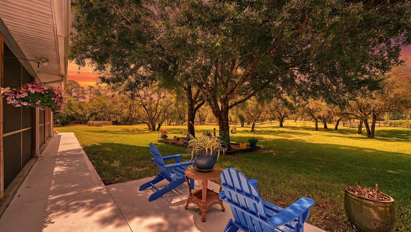 PHENOMENAL NEW PRICE!  Nestled at the very end of a private road on 10 +/- acres in Panther Ridge, this stunning gated estate offers rare seclusion and luxury on a beautifully wooded lot with a serene lake and fountain centerpiece. Completely reconstructed inside and out with virtually brand-new everything, metal roofs on both the main residence (3110' u/air) and the 12+ Car Collector’s garage (4464 u/air), Hardy Board siding, hurricane-rated doors and windows, all-new electrical (whole-house rewired), an impressive AC system with new duct work and 2 high-capacity units, and all-new plumbing. The entire property is fully fenced and cross-fenced, showcasing mature oak and pine trees. A custom wrought-iron staircase and stunning reclaimed oak and mahogany flooring pair beautifully with barn wood trim and accents throughout. Shiplap walls, knotty-pine accents, and plantation shutters complete the home’s signature look of quiet luxury. The gourmet kitchen features stainless steel appliances, a 6-burner Wolf gas range, quartz countertops and exceptional storage. Quartz counters continue in all bathrooms. Downstairs offers 2 spacious bedrooms including one huge 20 x 20 room that easily functions as a second primary, plus a Jack & Jill bath. Upstairs you’ll find the primary suite with a private screened L-shaped composite balcony, luxurious spa bath, and 21 x 14 walk-in closet, plus 2 additional guest bedrooms and guest bath. Outside, an expansive screened wrap-around porch on the first floor connects seamlessly to a resort-style heated saltwater 36 x 18 lap pool and 10-person spa, covered summer kitchen, and dramatic 2-story outdoor fireplace — the ultimate year-round entertaining space. Additional features include a laundry/mud room, upgraded Safetouch security system with dedicated cameras and internet, and in the downstairs primary a sound system with KEF speakers. Not to be missed-the oversized concrete block 3½-car garage (35 x 29) with RV hookup and future safe-room potential. Also on the property is a custom 15x20 combination of an a/c doghouse with runs and a brand-new, never-used state-of-the-art chicken coop. The true showpiece is the air-conditioned Car Collector’s Dream Garage (72 x 62) with 12-ft vaulted knotty-pine ceilings, rare sinker cypress feature wall, blue-vein knotty pine faux porch, gunmetal accents, custom stained concrete floors, car lift, 3 garage and 4 roll up doors, and RV hookup.  Imagine stepping into the Car Collector’s Dream Garage and feeling like you’ve entered a private automotive resort. Climate-controlled year-round, the 4,464 sq ft space features soaring knotty-pine ceilings that make every vehicle look like a museum piece, a dramatic rare sinker cypress feature wall, a blue-vein knotty pine faux porch perfect for relaxing with fellow enthusiasts, sleek gunmetal accents, and showroom-perfect custom stained concrete floors that are easy to clean yet incredibly durable. A professional car lift, 7 doors for effortless loading of trucks, boats or trailers, abundant LED lighting, a dedicated tool room with extra studs for customization, a large storage area, and an outside RV hookup completes this dream setup. Whether you’re restoring classics, detailing exotics, hosting car meets, or simply enjoying your collection in perfect comfort, this garage is built for serious enthusiasts who demand the very best. This is for the discerning buyer who wants a thoroughly modern home and an outstanding luxury car garage.