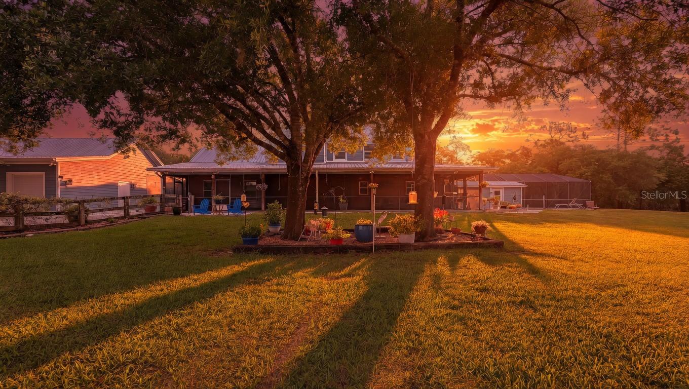 Nestled at the very end of a private road on 10 +/- acres in Panther Ridge, this stunning gated estate offers rare seclusion and luxury on a beautifully wooded lot with a serene lake and fountain centerpiece. Completely reconstructed inside and out with virtually brand-new everything, metal roofs on both the main residence (3110' u/air) and the 12+ Car Collector’s garage (4464 u/air), Hardy Board siding, hurricane-rated doors and windows, all-new electrical (whole-house rewired), an impressive AC system with new duct work and 2 high-capacity units, and all-new plumbing. The entire property is fully fenced and cross-fenced, showcasing mature oak and pine trees. A custom wrought-iron staircase and stunning reclaimed oak and mahogany flooring pair beautifully with barn wood trim and accents throughout. Shiplap walls, knotty-pine accents, and plantation shutters complete the home’s signature look of quiet luxury. The gourmet kitchen features stainless steel appliances, a 6-burner Wolf gas range, quartz countertops and exceptional storage. Quartz counters continue in all bathrooms. Downstairs offers 2 spacious bedrooms including one huge 20 x 20 room that easily functions as a second primary, plus a Jack & Jill bath. Upstairs you’ll find the primary suite with a private screened L-shaped composite balcony, luxurious spa bath, and 21 x 14 walk-in closet, plus 2 additional guest bedrooms and guest bath. Outside, an expansive screened wrap-around porch on the first floor connects seamlessly to a resort-style heated saltwater 36 x 18 lap pool and 10-person spa, covered summer kitchen, and dramatic 2-story outdoor fireplace — the ultimate year-round entertaining space. Additional features include a laundry/mud room, upgraded Safetouch security system with dedicated cameras and internet, and in the downstairs primary a sound system with KEF speakers. Not to be missed-the oversized concrete block 3½-car garage (35 x 29) with RV hookup and future safe-room potential. Also on the property is a custom 15x20 combination of an a/c doghouse with runs and a brand-new, never-used state-of-the-art chicken coop. The true showpiece is the air-conditioned Car Collector’s Dream Garage (72 x 62) with 12-ft vaulted knotty-pine ceilings, rare sinker cypress feature wall, blue-vein knotty pine faux porch, gunmetal accents, custom stained concrete floors, car lift, 3 garage and 4 roll up doors, and RV hookup.  Imagine stepping into the Car Collector’s Dream Garage and feeling like you’ve entered a private automotive resort. Climate-controlled year-round, the 4,464 sq ft space features soaring knotty-pine ceilings that make every vehicle look like a museum piece, a dramatic rare sinker cypress feature wall, a blue-vein knotty pine faux porch perfect for relaxing with fellow enthusiasts, sleek gunmetal accents, and showroom-perfect custom stained concrete floors that are easy to clean yet incredibly durable. A professional car lift, 7 doors for effortless loading of trucks, boats or trailers, abundant LED lighting, a dedicated tool room with extra studs for customization, a large storage area, and an outside RV hookup completes this dream setup. Whether you’re restoring classics, detailing exotics, hosting car meets, or simply enjoying your collection in perfect comfort, this garage is built for serious enthusiasts who demand the very best. This is a true one-of-a-kind estate built for the discerning buyer who wants privacy, quality, and the ultimate a/c bldg.