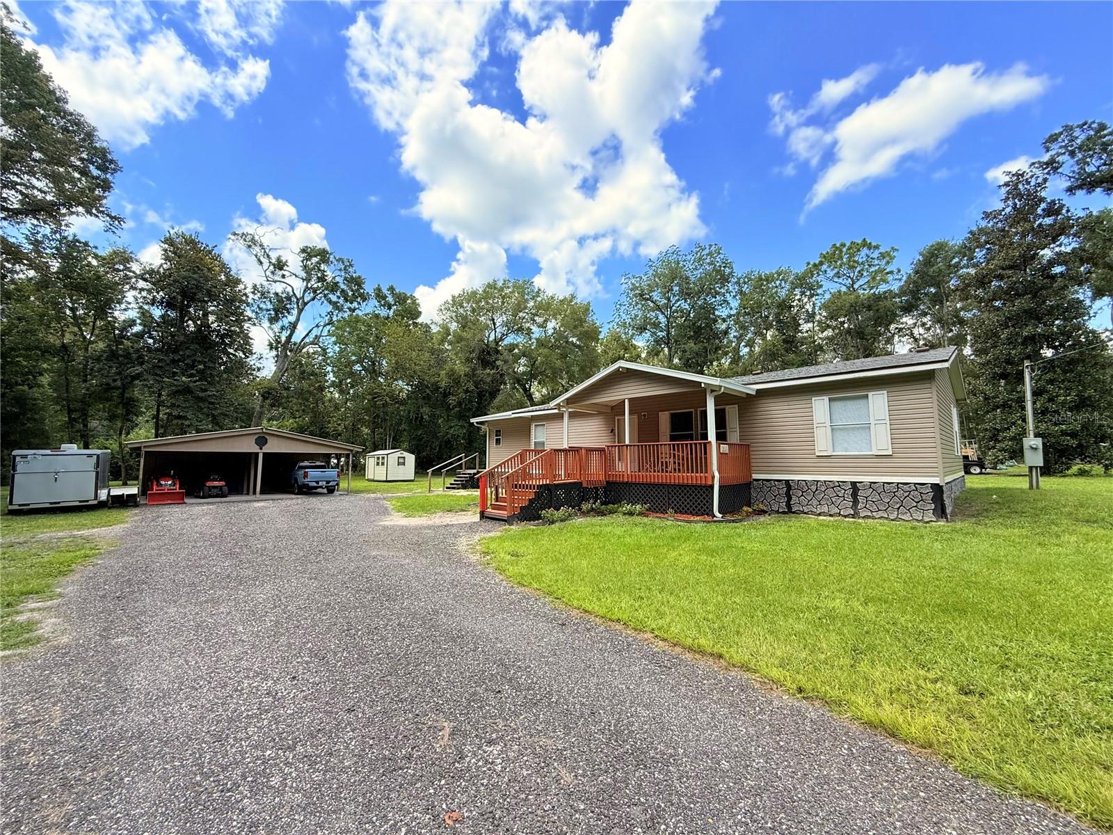Welcome to this beautifully remodeled home in the highly sought-after Three Rivers Estates community. The Owner recently enclosed the back-porch to be an additional room, it is AIR-CONDITIONED, and can be used as a 3rd BEDROOM, or IN-LAW SUITE. Situated on nearly two ACRES, this
charming 2-bedroom, 2-bathroom residence offers a thoughtfully designed living space with NO CARPET throughout. Upon entering, you’ll be
welcomed by a spacious family room featuring a striking custom slate tile feature wall, setting a warm and inviting ambiance. The upgraded
kitchen boasts modern appliances, ample cabinetry, and a well-planned layout that makes cooking a pleasure. Both bathrooms have been
stylishly updated with tile finishes, and the flooring throughout the home enhances its modern appeal. The master bedroom is an oversized suite with a huge walk-in closet, offering plenty of space and comfort. The guest bedroom is equally impressive, featuring its own large walk-in closet and enough space to serve as a true second master suite. As you make your way through the door in the kitchen you will notice a newly enclosed back porch that has also been air-conditioned! This enclosure has its own private door to exit the property, and an oversized private deck! This room could easily be a 3rd bedroom, In-Law Suite, or office/den! As Step outside and discover an impressive outdoor
setup, where the sellers spared no expense on landscaping. The expansive 1.84-acre lot provides plenty of space for outdoor activities. The
property also features a NEW water filtration system, and a NEW drain-field. Additional highlights include a POLE BARN covered pavilion with
electricity and a septic tank, offering the perfect setup for RV or camper parking. The detached OVERSIZED two-car carport comes with an
attached WORKSHOP, and a second shed in the backyard, both equipped with electric service, providing abundant storage and workspace.
Located just moments from the MEMBERS-ONLY boat launch and swim area on the Santa Fe River, this home is a dream for outdoor enthusiasts.
Don’t miss your chance to own this incredible property in a prime location with PRIVATE access to the Rivers. Schedule your private showing
today!