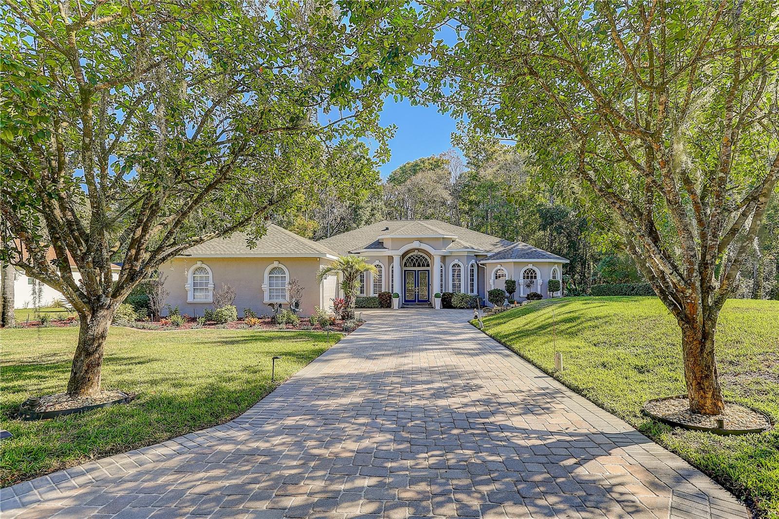 Seller to contribute up to $10k toward buyer closing costs. A rare hidden gem on 1.62acres, ONLY 30 minutes north of Tampa Airport. This 4 bedroom plus office, 3 full bath 3 garage pool home, offers 3,192 sq. ft. of refined living. NO CDD!LOW HOA, and a spotless record free from hurricane or flood impact, it delivers privacy, elegance, and peace of mind. Estate living begins as stately shade trees anchor the manicured grounds, casting a graceful canopy over the paver driveway that leads to a grand yet welcoming bay covered entry. Step inside: to the right, an office provides a quiet retreat; to the left, a formal dining room sets the stage for elegant gatherings, both with bay windows. The centerpiece is a soaring 12 feet high ceiling, highlighted with a tray ceiling up to 13.5 feet with crown molding. Expansive sliding doors connect seamlessly to the patio and sparkling saltwater pool, fully enclosed by a newly rebuilt no-see-um screen for year-round enjoyment. Beyond, the landscaped backyard stretches 30 feet into conservation, ensuring no future construction and complete seclusion from neighbors, only the beauty of lush greenery and blooming flowers. The gourmet kitchen boasts stainless appliances, 42-inch wood cabinets with crown molding, new quartz countertops, island, bar seating, and breakfast nook, together comfortably can host 50+ guests. The spacious 14x30 sq. ft. primary suite boasts the continuation of the living room’s impressive high-ceiling elegance and overlooks the serene backyard with bayed sitting area. Dual walk-in closets (including a custom California closet) and spa-inspired bath featuring dual vanities, makeup station, garden tub, and walk around shower. The left of the residence offers two bedrooms two full baths, a laundry room with utility sink and tons of cabinetry. A versatile fourth bedroom, currently a media room, can easily transform into an in-law suite with private patio entrance. The oversized three car garage space includes a bay for golf cart or workshop, plus a double-wide pull-across garage screen, instantly converting the garage into a breezy, pest-free space for hobbies, fitness, or entertaining. Located in the estate of Quail Ridge, with just 42 homes (most on 1+ acre lots) within a larger community of fewer than 300, this residence offers serenity amid Tampa growth. Here, timeless Florida charm thrives. Wild turkeys and sandhill cranes wander leisurely, and giant turtles amble slowly along the conservation edge. On some days, deer pause quietly before disappearing into the trees, a living reminder of the peaceful rhythm of nature. Classical Preparatory School, an A-rated K–12 charter school, consistently earns an “A” rating from the Florida Department of Education, is within golf cart distance, enriching family life with top-tier education. Just 2 minutes from Veterans Expressway (589), enjoy quick access: 30 minutes to Tampa International Airport, 40 minutes to Downtown Tampa, and seamless routes to Westshore business district, International Plaza, and County Line Road shopping and dining. Living here means you will never miss Tampa Bay’s vibrant events, sports, or waterfront activities, while still returning home to peaceful estate living. Roof (Sept 2021), HVAC 5-ton (July 2021) plus 2.5-ton for primary suite, brand-new septic (2025) and updated well system,new Quartz countertop. Ready to experience the perfect blend of acreage, upgrades, and tranquility? Schedule your private showing today!