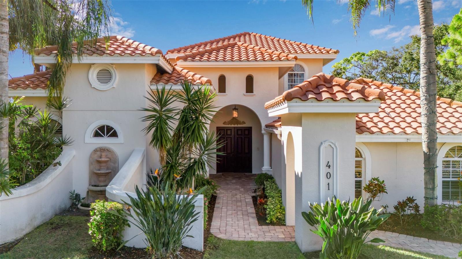 Perfectly positioned on the 9th hole tee box within the Oaks community, this meticulously appointed estate offers a rare opportunity for a premier Sarasota golf course lifestyle. Designed for the discerning enthusiast, the property features panoramic fairway views and western exposure for breathtaking sunsets. The interior is defined by soaring vaulted ceilings, refined crown molding, & finishes throughout.

The heart of the home is a curated chef’s kitchen featuring a bespoke butcher block island, professional-grade Viking double ovens, and sleek quartz countertops. High-end functionality includes dual KitchenAid dishwashers and custom cabinetry. The primary living spaces flow seamlessly to a wet bar and wood-burning fireplace, ideal for post-round entertaining. An extraordinary floating staircase of hand-built Hungarian wood leads to a versatile upper level with a private balcony overlooking the course.

The primary suite serves as a sanctuary, entered through exquisite hand-carved doors imported from Turkey. This retreat features French doors leading to a private courtyard, custom walk-in closets, and a whirlpool jacuzzi tub. Outdoor living is centered around the pool and an expansive lanai with a fully equipped summer kitchen. Notable infrastructure includes a 3-car garage, three AC units, and clear hurricane shutters. This residence offers an elevated Sarasota lifestyle with immediate proximity to world-class golf and the exclusive amenities of the Oaks community. Please note membership of The Oaks is required.