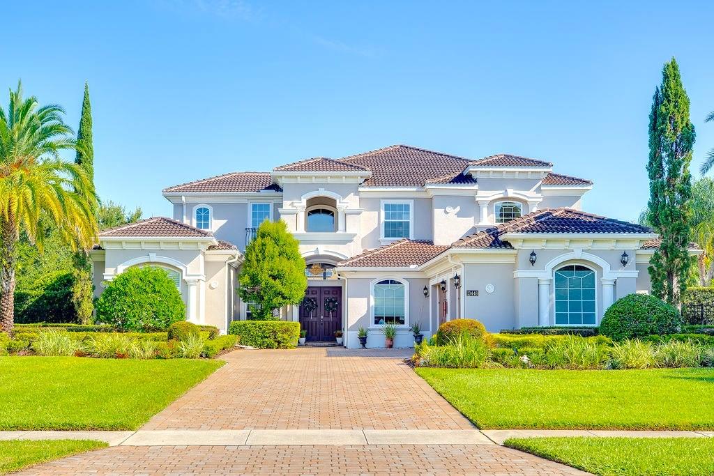 Buyer walked days before closing due to personal reasons! All inspections and milestones clean/clear!! - This exceptional Florida residence is perfectly sited on an acre within the exclusive guard-gated community of Bellaria. Thoughtfully designed to balance sophistication with comfort, the home welcomes you with an abundance of natural light streaming through broad front windows, highlighting the elegant handcrafted staircase in the foyer. The formal living and dining areas set the tone for refined entertaining, enhanced by a gas fireplace, a well-appointed wet bar, and expansive views of the sparkling pool and two-story covered porch. Just off the entry, the study provides an intimate retreat with porcelain flooring and clerestory windows, filling the space with natural light and framing serene outdoor vistas. The open-concept family room and kitchen create the heart of the home, where a wall of glass doors seamlessly blends indoor and outdoor living. The gourmet kitchen is a chef’s delight, featuring stainless steel appliances, exotic granite, custom cabinetry, tile flooring, and a spacious walk-in pantry. The first-floor master suite, thoughtfully tucked away for privacy, serves as a true sanctuary. Its spa-inspired bath is adorned with paneled cabinetry, exotic granite, a rainforest shower, soaking tub, and expansive closet areas—both beautiful and functional. Two additional en suite guest bedrooms, a versatile bonus room, and generous living and dining spaces make the main level ideal for everyday living or hosting. Upstairs, the thoughtful layout continues with three bedrooms, a loft, a sitting area, a bonus room, and even a second laundry room for added convenience. These flexible spaces adapt easily to the needs of a growing family or guests, offering opportunities for work, play, or relaxation. Blending elegance with livability, this home captures the essence of Florida living—where interiors open gracefully to resort-style outdoor spaces, making it perfect for both intimate family life and grand entertaining.