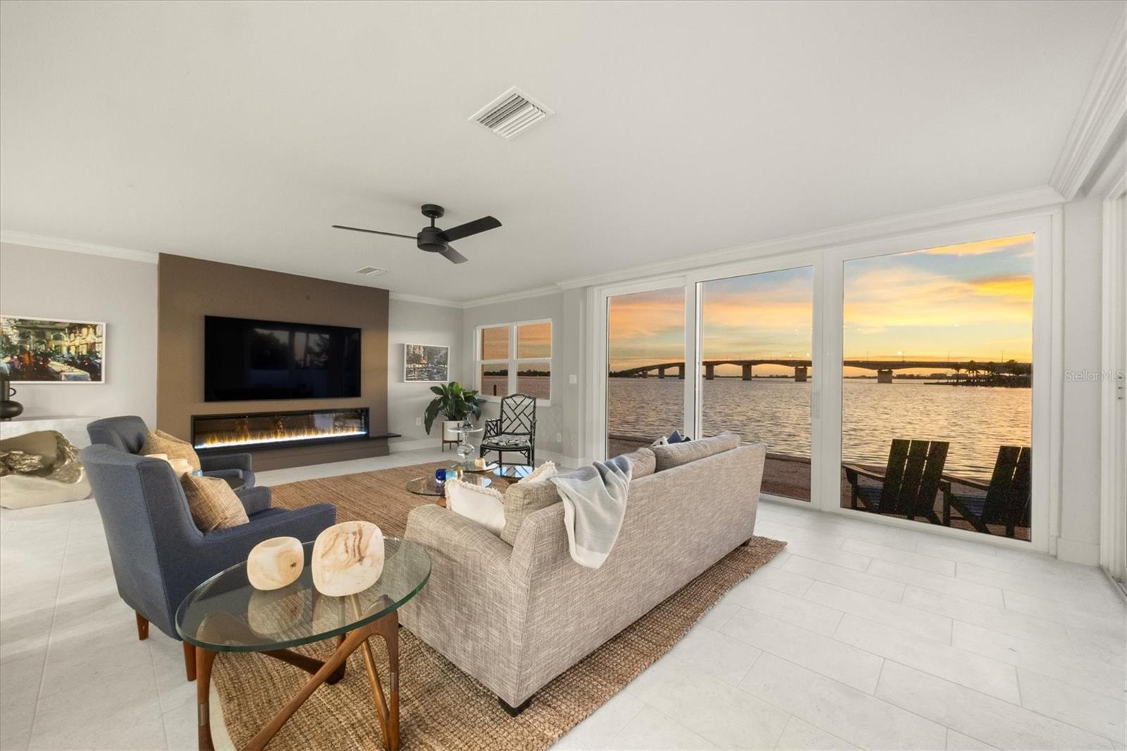 One or more photo(s) has been virtually staged. Fully renovated in 2025, this waterfront condominium residence at Harbor House West offers turnkey bayfront living on Golden Gate Point, one of Sarasota's most desirable waterfront neighborhoods. Enjoy sweeping Sarasota Bay, Ringling Bridge, and barrier island views from a move-in-ready residence ideally positioned within walking distance of downtown Sarasota and just minutes from St. Armands Circle, Lido Beach, and the city's renowned dining, arts, and cultural attractions. Combining the convenience of a lock-and-leave condominium with the lifestyle of a waterfront Sarasota residence, this thoughtfully restored and professionally redesigned home delivers low-maintenance coastal living in the heart of Sarasota. Thoughtfully restored and redesigned for modern coastal living, the light-filled interior features an open-concept layout that maximizes natural light, panoramic water views, and everyday functionality. Expansive sliders create a seamless connection between the living spaces and the private, enclosed waterfront patio, offering direct patio access, easy pet access, and effortless indoor-outdoor living year-round. The ground-floor setting enhances everyday convenience while creating a true extension of the home's waterfront living experience. The redesigned kitchen blends clean coastal styling with premium functionality, featuring quartz countertops, custom cabinetry, induction cooking, and a suite of upgraded GE and Fisher & Paykel stainless steel appliances. Adjacent to the kitchen, a dedicated laundry room with additional storage enhances everyday convenience. The primary suite serves as a peaceful waterfront retreat with expansive bay and bridge views, a custom walk-in closet, and a beautifully updated bath with dual-sink vanity, linen storage, and walk-in shower. Two additional guest bedrooms offer generous closet space, natural light, and flexibility for guests, seasonal living, or a home office. Following its comprehensive 2025 renovation, the residence offers refreshed interiors, updated finishes, and a move-in-ready environment designed for easy waterfront ownership, turnkey enjoyment, and lock-and-leave convenience. Thoughtfully modernized throughout, the home provides the confidence of completed improvements and a simplified coastal lifestyle. Additional highlights include assigned covered parking with future EV charger wiring in place, ample guest parking, pet-friendly living, and access to the community day dock. Harbor House West Condominium Association is a professionally maintained and well-managed bayfront community on Golden Gate Point, offering secure building access, day-dock amenities, and a premier waterfront location in Sarasota. Residents enjoy the confidence of an established waterfront community while benefiting from exceptional walkability to downtown Sarasota and convenient access to Sarasota Bay, Marina Jack, St. Armands Circle, Lido Beach, and many of the area's most celebrated restaurants, shopping destinations, and cultural venues.