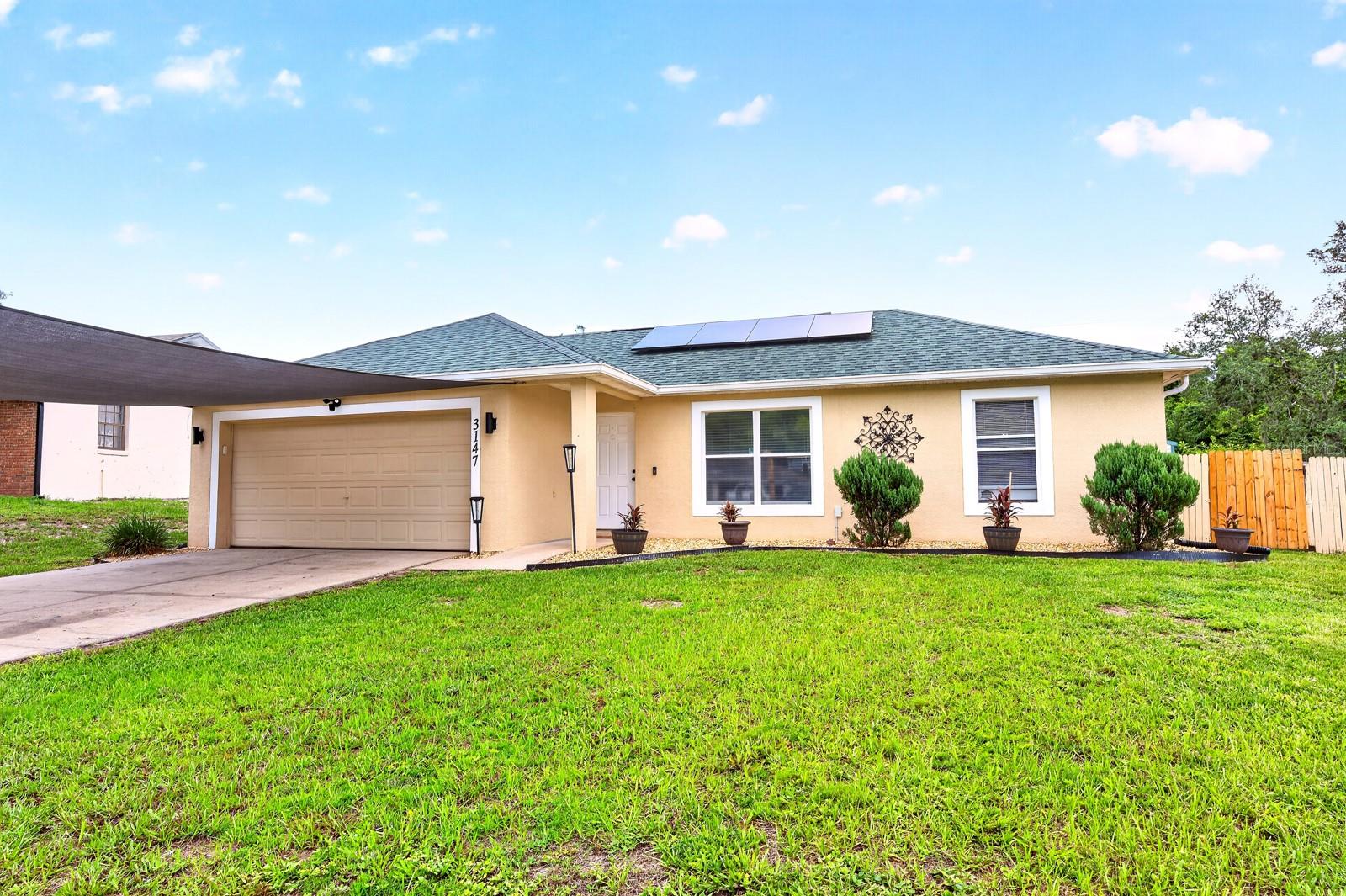 Fresh updates, energy-saving features, and NO HOA make this well maintained 4-bedroom, 2-bath block home on a spacious .24 ACRE LOT an opportunity you won't want to miss! Major improvements have already been taken care of with a NEWER WATER HEATER (2022), NEWER ROOF (2020), and UPDATED A/C (2018), while assumable SOLAR PANELS help keep monthly energy costs low. Inside, updated hardware and fixtures, LUXURY VINYL PLANK FLOORING throughout (with carpet in one bedroom), and VAULTED CEILINGS create a bright, welcoming feel from the moment you step inside. Designed with everyday living in mind, the versatile floor plan offers a formal living room, dedicated dining space, and a comfortable family room that flows seamlessly into the kitchen. The open kitchen is ready for everything from busy mornings to entertaining, featuring STAINLESS STEEL APPLIANCES, modern neutral countertops, a decorative backsplash, and two pantries providing exceptional storage. Two sets of sliding glass doors lead to the SCREENED LANAI, creating an easy transition to indoor/outdoor living while overlooking the oversized FENCED BACKYARD with plenty of room to play, garden, or add future outdoor amenities. The SPLIT BEDROOM layout provides added privacy, with the spacious PRIMARY SUITE tucked away featuring a vaulted ceiling, WALK-IN CLOSET, and an updated private bath. Three additional bedrooms share a well-appointed second full bath, offering flexibility for family, guests, or a home office. Conveniently located with quick access to I-4, SR 417, and US-17, you are just minutes from Dewey O. Boster Sports Complex, Saxon Park & Ride, AdventHealth Fish Memorial, the Central Florida Zoo & Botanical Garden, and the shopping, dining, and entertainment found throughout Deltona, DeLand, Sanford, and Lake Mary. This home is also zoned for “A” RATED Volusia Pines Elementary and Deltona High. With its updated features, spacious layout, energy-efficient solar system, and no HOA, this home is an excellent choice for a first-time buyer, growing household, or investment property. Schedule your tour today and let us say WELCOME HOME!