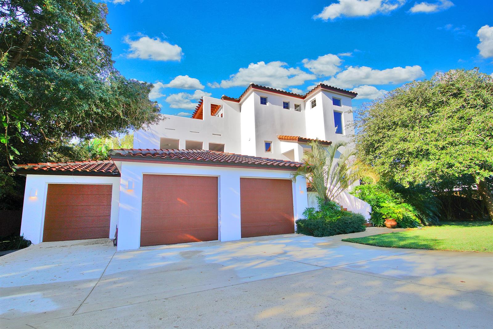Reminiscent of an opulent Italian villa, this magnificent multilevel Mediterranean inspired estate affords space, privacy, and luxury on an expansive 100X100 lot offering a new standard of elegance and sophistication in the landscape of highly coveted Ponce Inlet, Florida. This modern coastal home features an impressive 4,696 SqFt 3-story residence, shaded by stately live oaks, containing four bedrooms and four baths. An oversized three car garage with epoxy flooring offers plenty of storage space and easily accommodates multiple vehicles. Additional appointments include concrete block construction on all three floors, pre-wired for security system, wired for landscape lighting, hard coat plaster walls, variable speed A/C and 400 amp electrical panel.  The kitchen boasts solid wood cabinetry, a double under-mount stainless steel sink and updated GE Profile stainless steel appliances to appease any chefs dream. Venture into the sun filled living area featuring coffered ceilings with inlayed wood, recessed lighting and travertine flooring throughout. An oversized covered terrace with polished concrete flooring opens seamlessly off the living room. An outdoor haven ideal for entertaining, uncomparable sunrises, taking in the morning light and enjoying Ponce Inlet nights with friends.
An expansive master retreat with an ensuite bath encompasses the third floor of the home. Beyond the interior lies a private rooftop haven housing an outdoor shower and revealing uncomparable sunsets and sensational views of the Intracoastal waterway and the Atlantic Ocean, ideal for both relaxation and entertaining. If you're looking for a home that is the epitome of coastal Florida living, you've found it. You'll be impressed with the entertainer's backyard featuring a tropical outdoor oasis with ample space and pre-wiring for a pool. The tropical landscaping provides privacy and beauty with exotic plantings and towering mature live oaks.