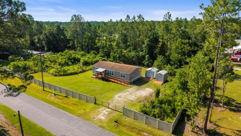 Nestled near the banks of the historic St John’s River, this property is perfect for that Astor Lifestyle!  Boaters, anglers, and nature lovers, here it is. Enjoy effortless access to world-class bass fishing, boating, and kayaking - you are just minutes away from local boat ramps, waterfront dining favorites, and the pristine waters of nearby natural springs. 3-bedroom / 2-bathroom mobile home, situated on a generous, fenced half-acre lot with double gate entrance. A secure, private outdoor space perfect for pets, children, and entertaining. Equipped with a sturdy wheelchair ramp for easy, step-free access to the home. Enter the freshly painted interior of this Split-Plan with high ceilings. Nice Open kitchen offers a breakfast bar and separate dining area. Primary Suite has plenty of room and a large Walk-In Closet. The Primary Bath has Dual Sinks and Walk-In Shower. 2 more bedrooms and a Full Bath at the opposite side of the home provide everyone with their privacy. Separate indoor Laundry. Wood deck in the back for grilling and chillaxing. Also includes two detached sheds with Roll-Up doors and wooden ramps for your tools, fishing gear, and outdoor toys. Generator Plug-In installed (bring your own generator). This is a Golf Cart Community. Whether you are looking for a full-time residence or a weekend fishing getaway, this property delivers the quintessential Old Astor charm.