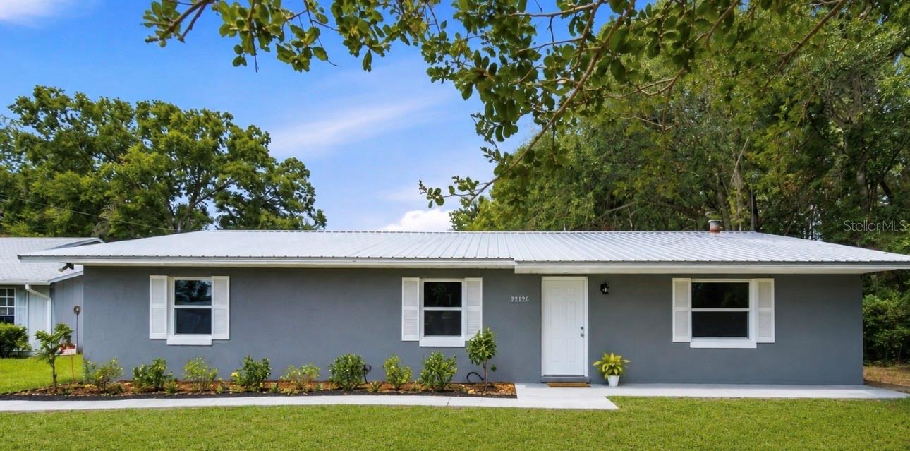 Virtually Staged. Better Than New – Fully Updated 3 Bedroom, 2 Bath Home in Lake Weir Gardens! Nestled in the established community of Lake Weir Gardens, this beautifully updated concrete block home offers the perfect blend of modern upgrades, quality construction, and a peaceful rural atmosphere—all while remaining conveniently close to shopping, restaurants, medical facilities, and everyday necessities.  This 3-bedroom, 2-bath home offers over 1,500 square feet of comfortable living space and has undergone extensive improvements, making it truly move-in ready. From the moment you arrive, you’ll appreciate the freshly landscaped grounds, newly painted exterior completed in 2026, and durable metal roof installed in 2021, creating exceptional curb appeal and a welcoming first impression. Step inside to discover a bright and inviting interior featuring luxury plank flooring throughout and an open-concept layout designed for today’s lifestyle. The beautifully renovated kitchen, updated in 2020, serves as the heart of the home with butcher block countertops, a stylish tile backsplash, stainless steel appliances, and a new dishwasher installed in 2026. The open design allows for effortless entertaining while keeping family and guests connected. Recent improvements include:
* Metal roof (2021)
* Complete interior and exterior paint (2026)
* Fresh landscaping
* New 3-ton, 14.5 SEER HVAC system (2026)
* New dual pane windows and exterior doors (2026)
* New well pump (2026) with a two-year warranty
* New dishwasher (2026)
* New ceiling fans, fixtures, switches, and receptacles throughout
Both bathrooms were completely renovated in 2026 with tasteful finishes, modern fixtures, and contemporary styling, creating a fresh, turnkey feel throughout the home. Step outside and enjoy Florida living from the spacious screened lanai overlooking the backyard. Whether you’re enjoying your morning coffee, hosting friends, or simply relaxing in the evening, this outdoor space provides the perfect extension of the home. The partially fenced backyard features newly installed fencing and offers plenty of room for pets, gardening, and outdoor enjoyment. Situated on just under one-third of an acre, the property also includes a detached two-car concrete block and stucco garage, providing ample room for vehicles, storage, hobbies, or a workshop. Plus a metal shed for added storage. One of the most appealing features of this property is the freedom it provides—there is no HOA and no deed restrictions, allowing you greater flexibility for your lifestyle, recreational vehicles, boats, trailers, and personal property. Combining extensive renovations, major system updates, fresh landscaping, and solid concrete block construction, this home delivers exceptional value and peace of mind. With nearly every major component already updated, all that’s left to do is move in and start enjoying the lifestyle you’ve been looking for. Beautifully renovated, thoughtfully updated, and truly better than new—this Lake Weir Gardens gem offers modern comfort, country charm, and the freedom of no HOA living. Make you appointment to see it today!