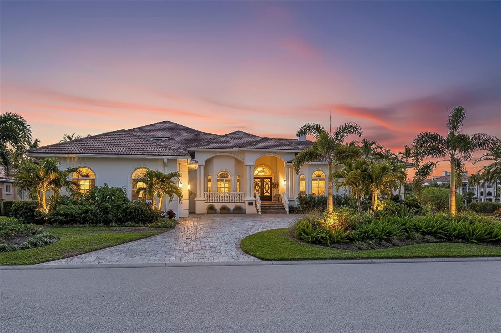 Welcome to Island House, one of the most compelling luxury offerings in Bayway Isles II. Set within the exclusive guard-gated enclave of Bayway Isles, this extraordinary Mediterranean residence occupies an expansive homesite and offers a rare combination of scale, privacy, luxury, and lifestyle. Spanning approximately one acre—including a portion of the lake—the home enjoys tranquil lake views, spectacular sunsets, and a remarkable sense of privacy rarely found within St. Petersburg's island communities.

Bayway Isles II remains one of Tampa Bay's most coveted addresses, known for distinguished residences, larger homesites, and an atmosphere of exclusivity. Encompassing nearly 6,400 square feet of curated living space and approximately 8,500 total square feet, the estate blends timeless architecture with modern refinement. Soaring 12-foot ceilings, marble flooring, solid wood doors with transoms, graceful archways, designer lighting, 2023 clay tile roof, and elegant finishes create a sense of understated grandeur throughout.

The chef's kitchen showcases premium appliances, leathered imported granite, custom cabinetry, an oversized island, veggie sink, and breakfast area flowing seamlessly into the great room. Luxury amenities include a climate-controlled 160-bottle wine room, butler's pantry, whole-home Sonos audio, upgraded theater technology, and extensive recent improvements.

The primary suite is a private sanctuary featuring a fireplace, morning bar, custom closets, and a spa-inspired bath with soaking tub, dual vanities, and steam shower. Two guest suites with en-suite baths are privately positioned opposite the primary wing, while a grand executive office and dedicated pool bath enhance functionality.

Designed for entertaining, Island House features a true stadium-seat theater with reclining chairs and popcorn station, along with a spacious media room. Upstairs, a private one-bedroom suite includes a large bath, walk-in closet, full kitchen, and separate living area—ideal for guests, multigenerational living, or extended stays. The upper level also offers the opportunity to create an extraordinary second primary suite or private wing.

Outside, the reimagined heated pool and spa feature newly installed tile, upgraded automation, lighting, equipment, and a saltwater system. A restaurant-caliber outdoor kitchen and separate outdoor bar with sink, refrigeration, and 85-inch television create an exceptional setting for sunset entertaining overlooking the lake.

With 24-hour guard-gated security and convenient access to Gulf beaches, downtown St. Petersburg, marinas, and Tampa International Airport, Island House represents a rare offering where architectural presence, exceptional amenities, and resort-style living converge. Despite its stunning water views and expansive grounds, the residence has never flooded. 

Recently repositioned to $3,749,000, Island House now represents the least expensive, pristine estate-sized residence currently available in Bayway Isles II. Whether envisioned as a private family compound, entertainer's retreat, or multigenerational residence, Island House offers a level of privacy, scale, and resort-style living rarely found along Florida's Gulf Coast. The home may be sold fully furnished too. 

Seller intends to review offers through the end of June while reserving the right to accept an exceptional contract prior to that time. Features and updates sheet available.