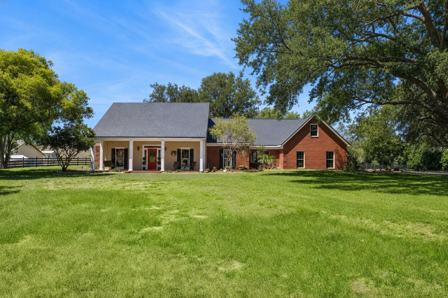 Tucked away on over 2.25 acres in the highly sought after equestrian community, The Trails of Montverde, this stunning 4 bedroom, 3 bath estate blends timeless traditional design with luxurious modern updates offering the kind of property and privacy that is getting harder to find in Central Florida. With just under 3,500 square feet, this home offers a thoughtfully designed floor plan that creates separation and privacy between spaces while still maintaining an inviting, natural flow throughout the home. No cavernous warehouse style open concept here, this one has warmth, character, and rooms that actually make sense. The heart of the home is the beautifully renovated kitchen, completed in 2022, featuring gorgeous marble countertops, updated finishes, and a layout designed for everyday living. The bathrooms were also fully remodeled in 2022 and feel straight out of a luxury boutique retreat, especially the stunning primary en-suite featuring a standalone clawfoot soaking tub and custom primary closet. Engineered hardwood floors run throughout the home, adding warmth and elegance, while the dedicated office provides the perfect work from home set up. Upstairs, the private fourth bedroom with its own en-suite bathroom creates an ideal guest suite, in-law space, or teenage hideaway. Step outside and the property truly unfolds into something special. The fully screened pool area is designed for peaceful outdoor living with a tranquil waterfall feature and expansive entertaining space overlooking the property with no rear neighbors in sight. Horse lovers will appreciate the 4 stall barn, equipt with an office with AC, a feed room and two paddocks.  The Trails of Montverde is one of the few true equestrian neighborhoods in the area, offering over 5 miles of private riding trails along with a private community riding arena. Whether your dream is horses, chickens, goats, gardening, or even keeping bees, this property gives you the flexibility and space to create the lifestyle you’ve been wanting. Additional major updates include a 2023 roof, septic system recently pumped and inspected prior to listing, and a rare commercial grade in house fire sprinkler system for added peace of mind. This is more than a home. It’s the kind of property that feels like its own slice of heaven the moment you drive down the oak canopied driveway.