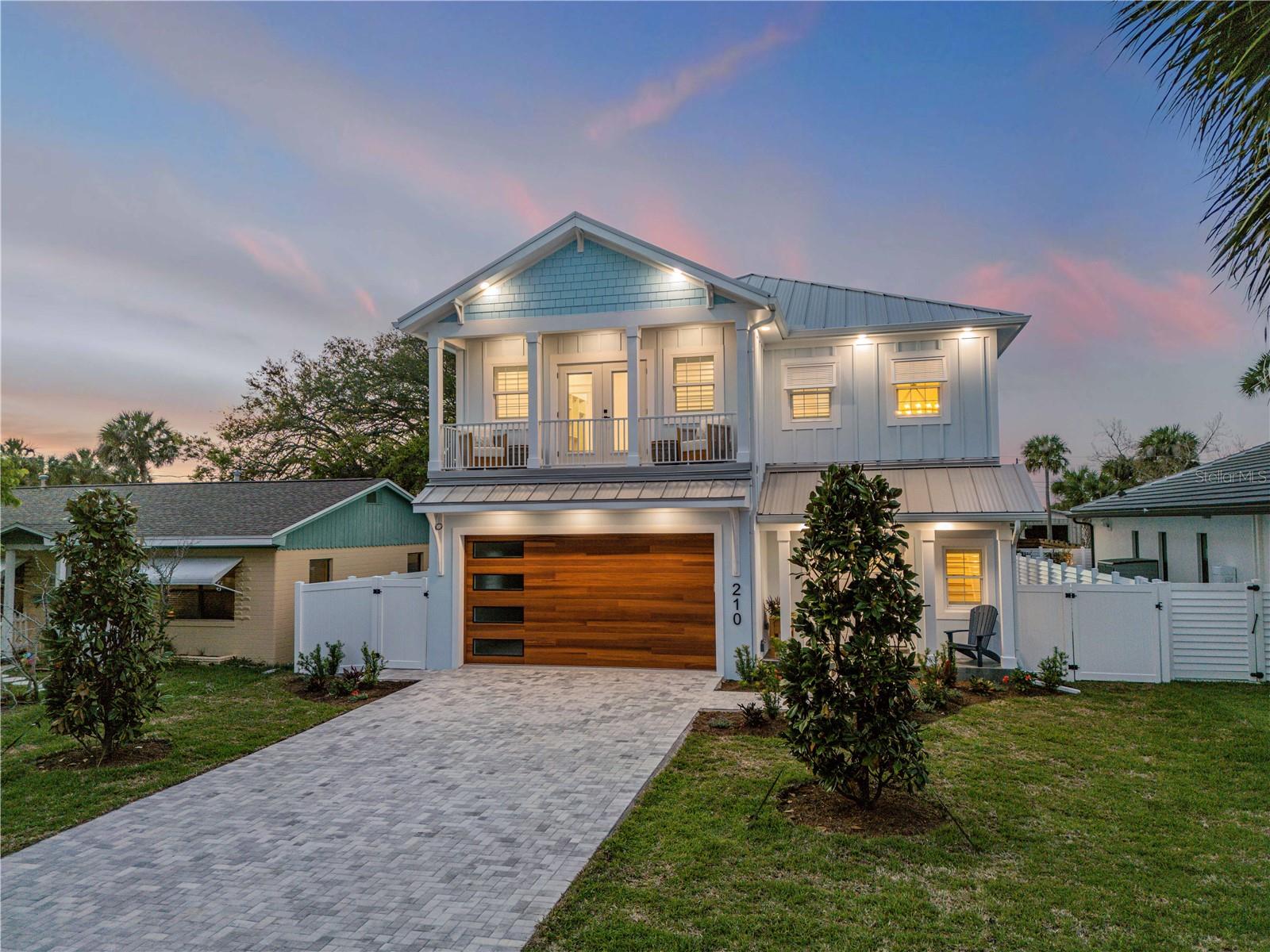 Experience the pinnacle of modern coastal luxury in this brand new 4 bedroom, 3.5 bath smart home, masterfully crafted to deliver an elevated lifestyle unlike anything else on the market. Every detail of this two-story residence has been curated to blend innovation, sophistication, & effortless comfort—all just moments from the Atlantic, where the fresh salt air can be enjoyed from either of two private balconies or your resort-style backyard oasis. A paver driveway leads to a striking double-door entry, setting the tone for the elegance found throughout. Inside, the home showcases an impressive array of integrated smart technologies, including dual Carrier AC units, multi-zoned electric control, the Eero Network, whole-house speakers, a 26 kW Generac generator, & fully automated top-tier GE Café appliances—all delivering extraordinary convenience at your fingertips. Recessed & premium lighting elevate the home’s ambiance, while locally crafted free-edge wood shelving adds warmth, artistry, & character throughout. The chef’s kitchen is the heart of the home featuring custom maple cabinetry, premium GE Café gas appliances, & a custom-built walk-in pantry designed for both beauty & functionality. This stunning culinary space overlooks a bright, open living area where hurricane-rated windows, high ceilings, porcelain tile flooring, & elegant lighting create an atmosphere of comfort & sophistication. A mounted television floats above a sleek electric fireplace, forming the perfect setting for both entertaining & everyday relaxation. Ascend the maple wood staircase, highlighted by exquisite designer fixtures, to discover the private upper level—home to all four bedrooms & a fully equipped utility room featuring a washer, dryer, & utility sink. The owner’s suite is a sanctuary unto itself, offering a boutique-style experience with a custom Birch wood California closet, a serene seating area, & a refined coffee bar with sink & refrigeration—ideal for quiet mornings on your private balcony. The spa-inspired en-suite bath impresses with floor-to-ceiling custom tile, a luxurious walk-in shower, dual sinks, & dedicated linen storage. This level also offers a secondary bedroom with its own custom en-suite bath, as well as two additional guest rooms that share access to the expansive second-story balcony overlooking the resort-style outdoor haven below. Step into a backyard paradise designed for the ultimate Florida lifestyle. A tranquil spill over hot-tub cascades into the heated saltwater pool creating a dazzling focal point, surrounded by elegant paver decking, a natural gas outdoor fireplace, an outdoor shower, & massive covered lanai complete with sink, counter space, & plumbing ready for your dream outdoor kitchen. Whether hosting gatherings or unwinding in total privacy, this space captures the very essence of coastal luxury. Additional features that elevate this home into a category of its own include an epoxy-floored two-car garage with dog wash station. The home is further enhanced for energy efficiency with standing seam metal roof for unmatched durability, spray-foam insulation, concrete block & Hardie-board construction, & full natural gas throughout. This home truly is a remarkable fusion of engineering excellence & refined coastal living, representing the best of modern innovation—crafted for those who demand the extraordinary. Beachside location, unmatched quality, & every amenity imaginable. This is coastal lifestyle defined.
