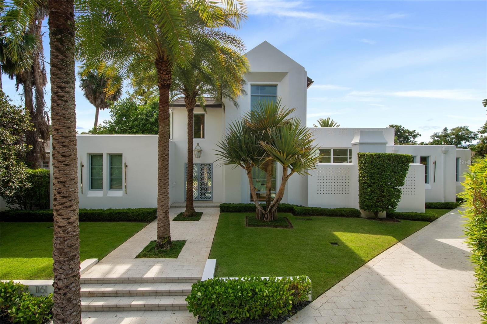 Conveniently situated near the Winter Park Country Club, this contemporary masterpiece, built by premier builder Z Properties, offers the ideal mix of style, comfort, and modern living. Meticulously maintained with great inspection. Completed in 2021, the residence has 4,181 square feet of thoughtfully designed living space, including four bedrooms each with a private ensuite bath and an additional powder room. A 412-square-foot casita with a wet bar and private entrance completes its functionality by providing extra flexibility, perfect for guests, extended family, workspace or workout area.
The interiors showcase timeless design with high ceilings, glass walls, and carefully curated finishes. The chef’s kitchen and butler’s pantry pair handcrafted cabinetry and stone surfaces with professional-grade appliances, flowing seamlessly into open living and dining spaces designed for both everyday living and entertaining.

Outdoors, a 65-foot lap pool anchors the private backyard retreat, complemented by a covered lanai, marine-grade summer kitchen, fireplace lounge, tree garden and lush landscaping. Solid block construction, advanced state-of-the-art home systems, and a climate-controlled two-car garage with an extended hidden driveway highlight the home’s privacy, quality, and convenience.

With a distinct European vibe under canopy trees and cobblestone streets in the desirable Valencia Terrace neighborhood, this home is just moments from Park Avenue’s boutiques, fine dining, Rollins College, the Farmers’ Market, and the Morse Museum. Zoned for top-rated Winter Park schools, it offers both luxury and practicality in one of Central Florida’s most sought-after communities.