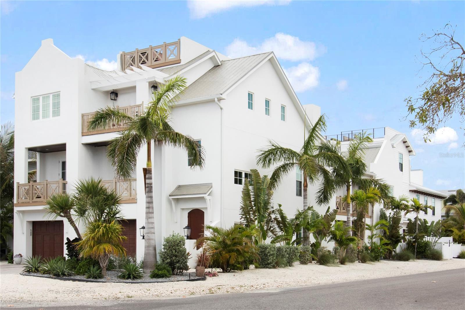 Located just two blocks from Bean Point on the coveted north end of Anna Maria Island, this beautifully designed 2023 residence offers a rare combination of privacy, walkability, and elevated coastal living. Never used as a rental, the home has been carefully maintained as a private retreat and is offered fully furnished. Professionally designed by Emily Moss Designs and recognized by SRQ Magazine as a 2025 Home of the Year, the residence blends architectural detail with relaxed island elegance.

The main living level features an open floor plan with coffered ceilings, gas fireplace, wet bar, powder room, and balcony access. The primary suite includes a private balcony, walk-in closet, dedicated laundry area, and a spacious spa-style bath with soaking tub and multi-feature shower.

The large chef’s kitchen is appointed with distinctive cabinetry, Thermador appliances, generous island seating for five, and an inviting eat-in dining area designed for effortless everyday living and entertaining.

A detached guest suite connected by a covered walkway offers its own private entrance, refrigerator, full bath, private balcony overlooking the pool, and garage—ideal for extended family or guests seeking independence and privacy.

Upstairs, two additional king en-suite bedrooms with vaulted beamed ceilings are centered around a private second-level sitting area with television, balcony access, and laundry room—creating a comfortable and well-separated guest retreat. Two rooftop decks capture sweeping Gulf views and vistas toward the Sunshine Skyway Bridge—perfect for sunrise, sunset, and evening skies.

Outdoor living centers around a beautifully landscaped private courtyard complete with pool, heated spa, putting green, and an expansive covered lanai designed for year-round enjoyment. A two-person dry sauna and flexible lower-level space add further comfort and versatility.

Constructed in 2023 with elevated hurricane-rated block construction, impact windows and doors, a metal roof, and low-maintenance composite decking, the home combines durability with thoughtful design. Elevator access to all living levels and multiple garage bays with gated boat or RV storage provide exceptional convenience and parking flexibility—rare on the north end. Situated on a desirable corner lot just moments from the Gulf and Pine Avenue, this is a unique opportunity to own a nearly new, designer-furnished island residence in one of Anna Maria’s most sought-after locations.  Detailed property brochure available.