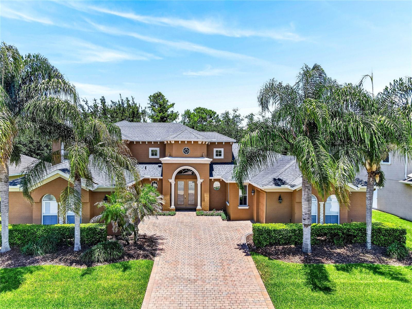 Amazing 5-bedroom, 4-bath Oviedo home with a 3-car garage, more than 5,000 total square feet, and no rear neighbors, located on a quiet street in the back of The Sanctuary. Enjoy peaceful conservation views throughout the community, along with state-of-the-art amenities including a fitness area, tennis and volleyball courts, resort-style pool facilities, and a playground. This desirable Oviedo location is known for top-rated public schools, parks, sports fields, and convenient access to the University of Central Florida, Full Sail University, area attractions, and beaches. The floor plan features a downstairs primary suite plus a second downstairs bedroom with pool bath, currently used as an office and craft area. Upstairs are three additional bedrooms, two bathrooms, and a loft that opens to a back balcony with majestic conservation views. The spacious downstairs living areas include 9-foot ceilings, 8-foot doors, a formal living room, formal dining room, spacious kitchen, breakfast nook, and family room—perfect for entertaining. Tile flooring enhances these main living spaces. Designed for Florida living, the home wraps around a large, covered lanai overlooking a private wooded conservation backyard. Extra-accent windows and two sets of glass sliders fill the home with natural light and beautiful views. Glass double front doors open to a dramatic foyer with 19-foot ceilings, a formal living room, and a lovely staircase with oak banister and white spindles that continue along the open loft. Custom lighting, tray ceilings, crown molding, and solid wood cabinets in the kitchen, laundry room, bathrooms, and office add quality and character throughout. All appliances convey, including a GE washer and dryer (2023), Whirlpool refrigerator (2020), Maytag dishwasher (2022), built-in oven, cooktop, microwave, and disposal. The private primary suite offers an extended sitting area and two walk-in closets. The primary bathroom includes two raised vanity areas, a prep/sitting counter, garden Jacuzzi tub with glass-block window, and spacious double-headed shower. The dedicated laundry room includes cabinets, shelving, and a utility sink. Brick pavers enhance the back lanai, front porch, and courtyard driveway, complementing the home’s beautiful Mediterranean-style architecture. The split 3-car garage and courtyard driveway provide added parking. Recent updates include all three HVAC units replaced (2018, 2019, and 2023), 80-gallon hot water heater (2020), roof with gutters and downspouts (2015), exterior high-quality paint (Spring 2026), and interior high-quality paint (2025). 2-car garage is 21 x 20 & 1-car garage is 21 x 10. Meticulously maintained and move-in ready—call today to schedule your showing.  (The land behind 3198 Heirloom Rose Pl is owned by the community and it will never be developed; it is a buffer behind this property.)