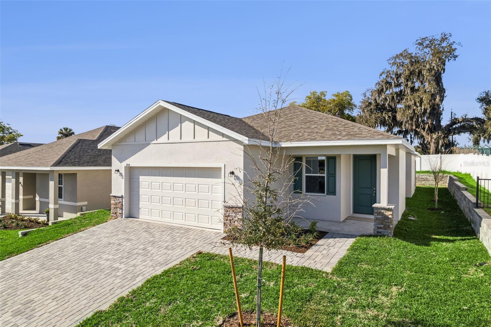 Welcome to The Hurley Model, a beautifully designed new construction home in the quiet and serene Grand Isle community. Offering the perfect balance of style, functionality, and value, this thoughtfully designed home features 3 bedrooms, 2 bathrooms, and 1,761 square feet of open living space with over 2,500 square feet under roof. From the moment you arrive, the curb appeal sets the tone with a beautiful paver driveway and lead walk, upgraded stone front elevation, decorative shutters, and professional landscaping with St. Augustine sod and a full irrigation system. The welcoming 8-foot front door opens into a light-filled interior with 9’4” ceilings and a spacious open floor plan designed for modern living. At the heart of the home is the beautiful kitchen, featuring granite countertops, white cabinetry with knobs and pulls, a large island perfect for gathering, stylish pendant lighting and a large corner pantry. The kitchen also includes a full stainless steel appliance package including a side-by-side refrigerator, plus ample counter & cabinet space for storage. The open living and dining areas create an inviting space for entertaining or everyday living, while the rear door leads to a covered patio, perfect for enjoying Florida evenings or weekend cookouts. The primary suite offers a private retreat with a spacious walk-in closet and a well-appointed en-suite bathroom with dual sinks and a large walk-in shower. Two well-sized additional bedrooms provide flexibility for family, guests, or a home office. Situated on an end homesite, this property offers added privacy, creating a peaceful setting with fewer neighboring homes and a more secluded backyard feel. Throughout the home you’ll appreciate the builder upgrades and thoughtful details, including granite countertops, ceramic tile in wet areas with additional tile in the dining room and hallway, exterior garage coach lights, faux wood blinds, and a garage door opener. Located in the Grand Isle community, residents enjoy a low HOA and no CDD, while being conveniently close to downtown Eustis, Mount Dora, shopping, dining, lakes, and outdoor recreation. Builder FLEX CASH special is currently available, to assist with closing costs, interest rate buy-downs or additional upgrades - making this beautiful new home an even better opportunity. Come discover the quality, value, and thoughtful design that make Summerpark Homes stand out.