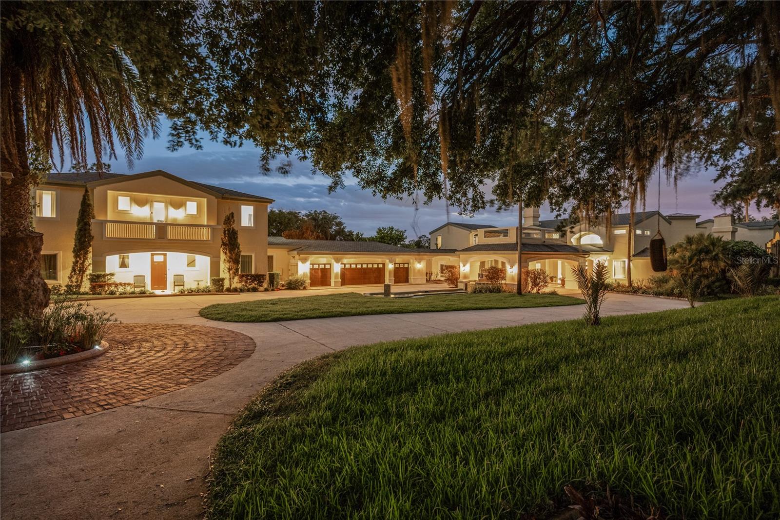 Introducing Palazzo Vecchio a remarkable legacy estate situated on The Butler Chain of Lakes. Crafted by renowned luxury builder Akers Custom Homes, this Italian-inspired gated compound spans 4.37 acres of land, offering an unrivaled 275+ feet of direct lake frontage and a level of privacy and grandeur rarely seen in Central Florida. Beyond a private gated entrance, a long, sweeping drive winds down to an expansive porte-cochere, setting the tone for what awaits. The estate unfolds like a European retreat, complete with a four-car garage, manicured grounds, and a private tennis court. Inside, soaring 22-foot ceilings and dramatic walls of glass immediately frame panoramic lake views, flooding the interiors with natural light. The grand great room is anchored by a statement marble fireplace adorned with intricate detailing, an architectural focal point designed for both intimate evenings and elevated entertaining. The chef's kitchen is a masterpiece of scale and functionality, centered around an enormous island ideal for gathering, complemented by stainless steel appliances and generous prep space. Nearby, the formal dining room offers a grand and sophisticated setting with sweeping lake vistas and a custom mosaic tile floor. The primary suite occupies its own private wing, an elevated sanctuary designed for true retreat. Complete with a sitting lounge, dual private balconies, a private bar station, and a spa-inspired bath featuring a grand soaking tub, expansive walk-in shower, and separate bespoke his and hers walk-in closets, it is a residence within the residence. Four additional bedrooms which are all ensuite in the main home provide luxurious accommodation for family and guests alike. Elevated lifestyle amenities include a dedicated home office with custom built-in cabinetry, a private movie theater, and an expansive game room perfect for entertaining on a grand scale. Outdoors, the estate transforms into a private resort. A massive dual level covered lanai flows effortlessly to a resort-style pool and spa, while a 400-square-foot cabana, complete with a summer kitchen, bar, bathroom, and outdoor shower, offers the ultimate setting for lakeside entertaining. The wide, open backyard featuring scores of organic fruit trees such as mango, banana, fig, passionfruit, and guava as well as 300 feet of active vegetable garden rows leads to a private dock with dual boat slips, offering immediate access to the coveted Butler Chain and views of Disney fireworks at night. A thoughtfully designed mudroom also features extended custom built-ins, offering both elegant storage and everyday functionality for a beautifully organized entry space. Complementing the main residence, a fully appointed guest house offers four additional bedrooms, one currently used as a private gym, a full kitchen, living room, a full English bar/entertaining space with dual balconies, children's play are and its own private entrance ideal for extended stays, multigenerational living, or executive guests. Originally conceived as an extraordinary waterfront residence, the estate was further elevated in 2019 with the addition of an expansive 3,500-square-foot addition, thoughtfully designed to enhance both the scale and lifestyle experience. Opportunities of this magnitude are extraordinarily rare, Palazzo Vecchio is not simply a home; it is a once-in-a-generation offering destined for the most discerning buyer.