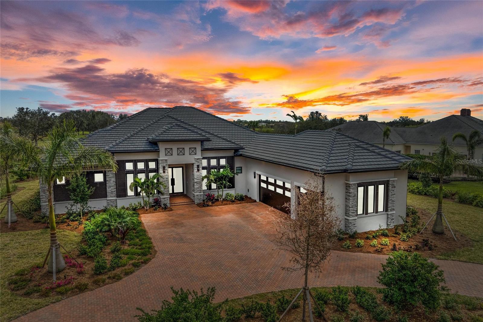 Step into the epitome of luxury living with this brand-new, custom-designed masterpiece by John Cannon Homes. Situated in the luxury,  private community of The Founders Club, this 2024-built home exudes sophistication, impeccable craftsmanship, and state-of-the-art finishes that cater to the most discerning tastes. Perfectly positioned on a coveted homesite, this residence offers sweeping views of the 11th hole of the championship golf course, serene lake vistas, and lush preserve landscapes—creating an idyllic backdrop for everyday living. From the moment you enter, you’ll be captivated by the spacious, open-concept design and soaring 11-foot ceilings that allow natural light to flood the home. The expansive Great Room features a stunning electric fireplace, a tray ceiling, and double pocket doors that seamlessly connect the indoors to the covered lanai, ideal for entertaining or simply enjoying the outdoors in privacy. The gourmet kitchen is a chef’s dream, complete with top-of-the-line Wolf appliances, including a 6-burner gas stove, Sub-Zero refrigerator, and built-in coffee system. It’s complemented by a large walk-in pantry and custom cabinetry, providing both style and functionality.
The luxurious Primary Suite serves as a private retreat, with a cathedral wood-paneled ceiling, dual walk-in closets with custom shelving, and an en suite bath that rivals a spa. The bath features a garden tub, oversized walk-in shower, and dual vanities, offering the perfect space to unwind and relax. A dedicated private study, separated by custom barn doors, provides a peaceful and stylish workspace, while the bonus room is designed for entertainment, featuring a wet bar, wine refrigerator, ice maker, and floating shelves for added flair.
For added privacy and versatility, the home includes a private guest suite within a detached Casita, complete with a full bath and walk-in closet, offering guests comfort and seclusion. Designed for the ultimate in outdoor living, the home features a sparkling saltwater pool and spa, perfectly positioned to enjoy the unobstructed views of the golf course, all enclosed by a clear view screen for ultimate privacy. A custom outdoor kitchen invites alfresco dining and entertainment in a tranquil setting. Every detail of this home has been thoughtfully curated, including high-end designer furnishings that are included with the sale, ensuring a move-in-ready experience. The property also offers a whole-house speaker system, a backup generator, and impact-resistant windows for peace of mind, while the smart home technology allows for effortless control of lighting, climate, and security.
Living in The Founders Club offers more than just a home—it’s a lifestyle. With a 24-hour guard-gated entrance, residents enjoy access to world-class amenities including Har-Tru tennis courts, pickleball, basketball and volleyball courts, and a vibrant social community with events year-round. Optional membership to the club provides access to the 18-hole championship golf course, a well-appointed clubhouse with dining and fitness facilities, and more. Located just minutes from world-class shopping, acclaimed dining and entertainment, A-rated schools, and top tier medical facilities and just a short drive to the cultural heart of downtown Sarasota and award-winning beaches. This extraordinary provides the perfect balance of privacy, luxury, and comfort. Don’t miss the opportunity to own this stunning, unparalleled, turnkey property.