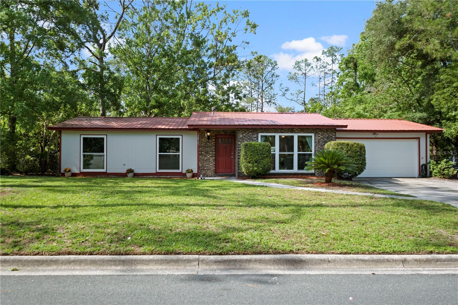 Welcome home to this beautifully updated property nestled on a spacious lot with mature trees and plenty of room to enjoy the outdoors. Inside, you'll find a bright and inviting floor plan featuring fresh carpet, updated bathrooms, abundant natural light, and a spacious living area that flows seamlessly into the dining room and kitchen. The kitchen offers updated cabinetry, granite countertops, stainless steel appliances, and a convenient island perfect for meal prep and entertaining. Major improvements provide peace of mind for years to come, including a metal roof (2015), HVAC system (2019), complete PEX repipe (2022), water heater (2022), energy-efficient windows (2022), updated appliances (2022), and a new garage door (2026). The large backyard offers endless possibilities for gardening, pets, play, or future outdoor living spaces. With its extensive list of upgrades, move-in-ready condition, and desirable northwest Gainesville location close to shopping, dining, parks, and the University of Florida, this home is a rare opportunity you won't want to miss.