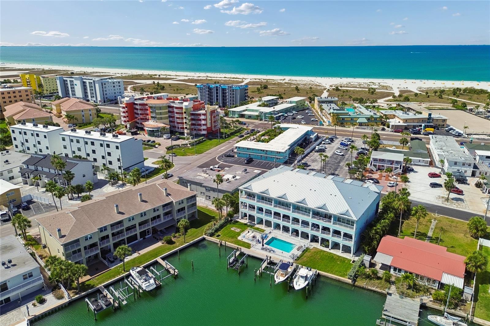 Large townhome with private boat slip with direct Gulf access in Treasure Island. Make daily beach sunsets part of your every day. Just steps from award-winning white sand beaches, a deeded boat slip with a 10,000-lb lift, and a covered waterfront terrace framed by flowering hibiscus — this is the Florida dream address. Direct canal access to John’s Pass puts you in the Gulf in under five minutes, and Treasure Island’s celebrated beach is just steps from your door.
The ground level sets the tone immediately — a covered terrace and paved patio right on the water, beautifully landscaped with tropical hibiscus, with room for lounges, tables and chairs. Your boat slip with 10,000-lb lift sits on a stunning wide canal alive daily with tiki bar boats, kayakers, paddleboarders, dolphins and manatees. The oversized deep garage accommodates three vehicles, a workshop and all your water toy storage, and includes a dedicated 220-volt line — ideal for an EV charger or hot tub. A wide paver driveway provides additional parking right at your door.
Head upstairs to the main living level and the width and light immediately impress — this is nothing like a typical Florida townhome. Water views from the living room, dining room and kitchen. Cozy up to the fireplace on those perfect Florida evenings, then step out onto the full-width balcony spanning the entire width of the home — room for lounges, seating and a bistro setting with warm Gulf breezes and shimmering canal views. The kitchen features a large island, wine fridge, bar fridge, abundant granite countertops and generous storage. Steps from Gulf Boulevard, the beach trolley makes getting to the award-winning beach effortless.
The entire third level is dedicated to all three bedrooms including a true primary suite — private balcony with water views, fully remodeled spa bath with gorgeous quartz surfaces, dual showerhead walk-in shower, built-in shelving, soaking tub and custom walk-in closet system. Additional bedrooms are generously sized. Brand new driftwood-style porcelain tile flooring throughout. Laundry on this level. Hurricane-rated windows throughout; hurricane shutters on large openings.
Your HOA has you covered — roof replacement, exterior paint and grounds maintenance are all included, so you can simply enjoy the lifestyle you came here for.
Rosselli Park is walking distance — dog park, pickleball, shuffleboard, basketball, playground and covered pavilion. Publix, pharmacy, liquor store, coffee shops, restaurants and bars all on the island. Cruise the beachfront walking corridor or hop in your golf cart — Treasure Island is a golf cart friendly town. Famous Downtown St. Pete is 20 minutes away. Tampa International Airport — consistently ranked one of the best in the country — is 30 to 45 minutes door to gate. Three bridges connect the island to the mainland, keeping beach access remarkably traffic-free. Sunday night drum circles, breathtaking sunsets and some of America’s most celebrated beaches right outside your door.
This is Treasure Island living at its absolute finest — schedule your private showing today before this one is gone.