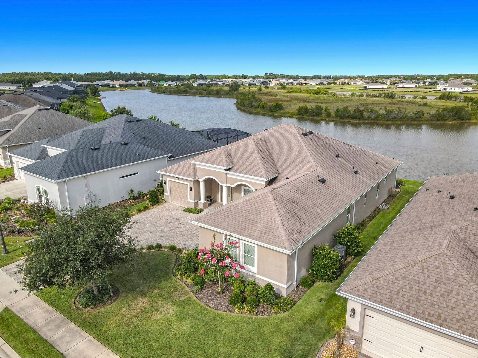 One or more photo(s) has been virtually staged. Custom-built in 2019 by Medallion Home, this residence features the builder’s famous and highly sought-after Santa Maria design—a top choice for buyers seeking efficient flow 3 bedrooms 3 baths generous room sizes, and premium construction. Positioned on a desirable waterfront lot in the award-winning Lakes of Mount Dora, this home delivers modern efficiency, quality finishes, and clear, unobstructed lake views.

The home includes Land Blanc 21" porcelain tile throughout, cathedral ceilings, large crown molding, tray accents, interior 8-ft doors, a central vacuum system, two tankless gas water heaters, Double pane, Low-E windows and sliders, garage storage shelving, foyer ceiling detail, gas cook top, gutters, paver walkways, lanai and driveway. Lightning rods added for enhanced storm protection. 

The gourmet kitchen features Maple Chiffon soft-close, full extension upgraded cabinetry, quartz kitchen countertops with waterfall side and a full quartz backsplash. A drop-tray ceiling defines the breakfast nook and adds architectural detail.

The main living areas have an open layout with large windows that bring in natural light and water views. A separate media room with lake views provides flexible living space and direct access to the enclosed sunroom, which is fully finished with its own HVAC system for year-round use.

The primary suite includes water views and a well-appointed ensuite with a walk-in shower, custom cabinetry, and generous walk-in closets. Guest rooms are well-sized and provide privacy for visitors or workspace needs.

Two separate garages provide three-car capacity, epoxy flooring, and built-in storage, ideal for car enthusiasts or hobbyists.

The covered lanai overlooks the water and has ample room for a future pool, creating a versatile outdoor living area with sunset views.

Residents enjoy resort-style amenities, including a beautiful pool with a beach entry, clubhouse with full social Calander, fitness center, pickleball, walking trails and RV- Boat storage— just minutes from historic downtown Mount Dora’s dining, shops, and waterfront events.