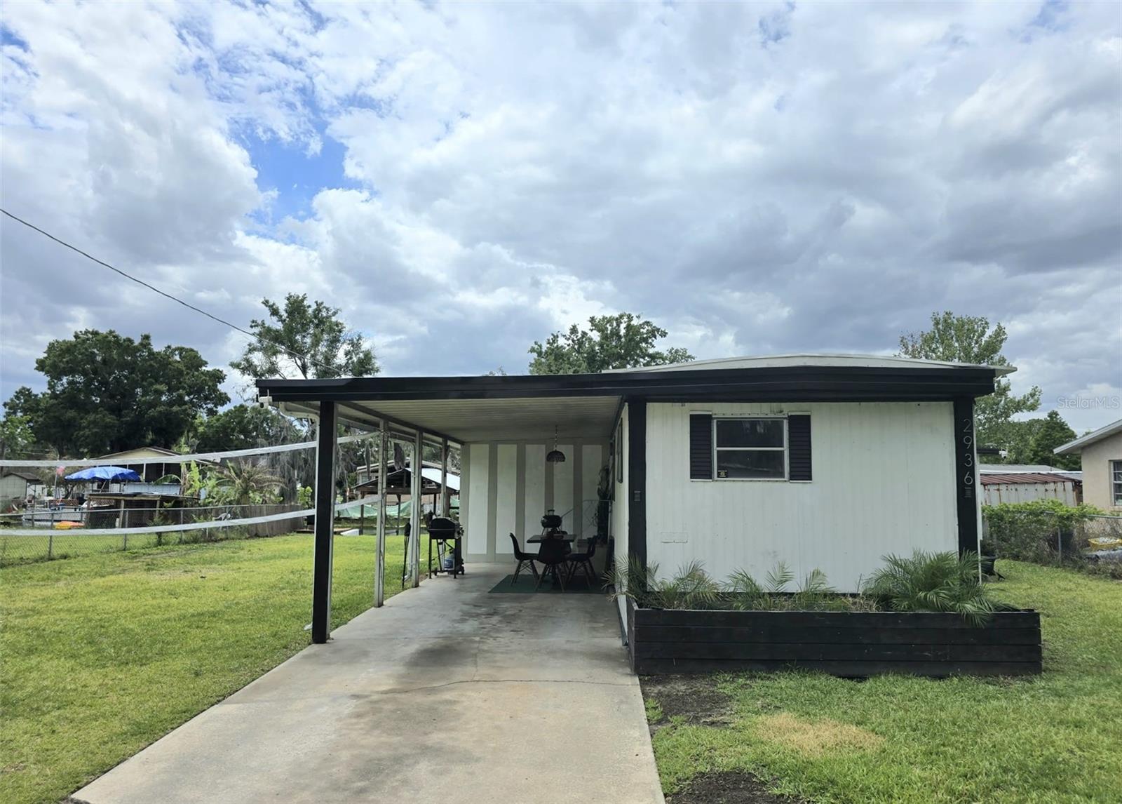 Perfect sanctuary for anyone who enjoys boating, fishing, or relaxing by the water. Welcome to this 3 bedroom 1.5 bath single-wide home in Haines City, Florida—with NO HOA & NO LOT FEE! Conveniently located near the new Crossroads Village Center, you’ll have easy access to shopping and dining, including Target, Ross, PetSmart, and Panera Bread. Inside, the living room opens to the kitchen and dining area, creating a comfortable, open layout. The kitchen includes a electric range, large single basin sink, wooden cabinets, and quartz countertops. The primary bedroom features two closets and its own full bathroom. From here, you can step out to a screened-in patio—perfect for relaxing. The second bedroom is on the opposite side of the home and includes a half bath. The home also offers extra hallway storage, a bonus room,  a newer A/C system, and durable metal roof and siding. Outside, you’ll find a partially fenced yard and plenty of parking with a carport and driveway. Enjoy direct canal access from the property—launch a kayak or small boat and head out to Lake Lowery. Additional boat ramps nearby make it easy for larger boats. A great opportunity for anyone looking to enjoy outdoor living with nearby conveniences. Call today for a private showing!