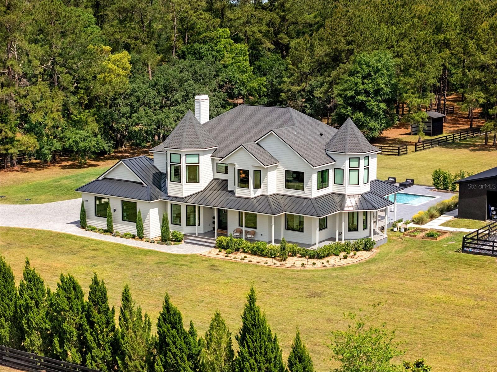 Set on a breathtaking 4-acre estate, this extraordinary luxury residence offers an unmatched blend of modern European elegance, resort-inspired amenities, and future expansion potential. Encompassing 5,066 total square feet, the property features a stunning 4,204 sq ft main residence paired with an impressive 863 sq ft private gym addition completed in 2024. Designed for both grand entertaining and everyday comfort, the estate is surrounded by lush, modern European-inspired landscaping accented by over 26 mature juniper trees and a towering 7-foot Ligustrum privacy hedge that creates a secluded, castle-like atmosphere from the moment you arrive through the automatic security gate and Portuguese cobblestone driveway.
Inside, exceptional craftsmanship and curated finishes define every space, including thermally broken aluminum European windows and doors, a dramatic custom pivot entry system, and Norwegian white oak engineered hardwood flooring throughout. Outdoors, the resort-style experience continues with an oversized pool and spa featuring automatic controls and an expansive Italian large-format tile patio deck, alongside a private pickleball and basketball sport court designed for recreation and entertaining alike.
Offering rare flexibility, the estate includes a separately parceled 2-acre homesite with utilities already in place and approved for expansion—ideal for a guest residence, mother-in-law suite, or the creation of a private family compound. Additional highlights include a brand-new roof installed in 2023, whole-home backup generator with a 750-gallon underground propane system, hobby barn, two fully boarded no-climb fenced pasture turnouts, and a new livestock shelter.
Location is everything, and this estate places you in the perfect balance of privacy and accessibility. Conveniently situated just approximately 45 minutes south of Tampa International Airport and 45 minutes north of Ocala, the property offers effortless access to world-class travel, dining, entertainment, and equestrian destinations while still enjoying the serenity of luxury country living.
A truly rare offering where luxury, privacy, lifestyle, and long-term potential seamlessly come together in one remarkable estate.