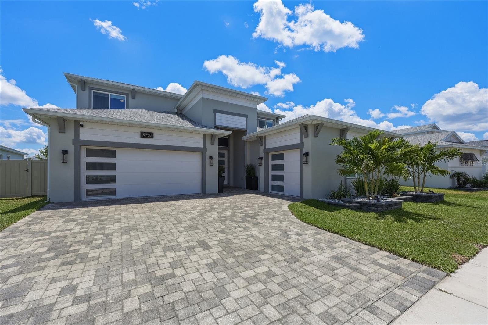 Experience luxury living at its finest in this highly upgraded modern home located in one of Wesley Chapel's most desirable communities. Perfectly situated just minutes from Eagle Park, top-rated schools, shopping, dining, and everyday conveniences, this home offers an exceptional combination of style, comfort, technology, and resort-style outdoor living.
From the moment you arrive, the striking modern elevation, extended paver driveway, full gutter system, and meticulously maintained landscaping create impressive curb appeal. Inside, luxury vinyl plank flooring flows throughout the main living areas, complemented by tile flooring in all bathrooms and the laundry room, and upgraded carpet upstairs.
The heart of the home is the spectacular chef's kitchen, designed for both entertaining and everyday living. Featuring a custom 10-foot island, ceiling-height cabinetry with under-cabinet lighting, premium appliances, a walk-in pantry, and a convenient pot filler, this kitchen is as functional as it is beautiful.
The open-concept design seamlessly connects the kitchen, dining, and living spaces while overlooking the home's private outdoor oasis. Step outside to enjoy a custom 7-foot-deep saltwater pool and spa surrounded by an expansive screened lanai and extended paver patio, creating the ultimate Florida backyard retreat.
The luxurious primary suite feels like a private spa, featuring a 21-inch-deep soaking tub, oversized walk-in shower with dual shower heads and a rain shower, and custom closet organization systems.
A first-floor guest suite provides privacy for visitors or for use as an in-law suite/ADU, while the dedicated office features a custom king-size Murphy bed and closet system, allowing the room to easily function as an additional guest space when needed.
Designed with today's lifestyle in mind, this smart and connected home is equipped with exceptional technology and convenience features, including CAT 6 wiring in every room, pre-wired 7.1 surround sound in both the living room and upstairs bonus room, and in-ceiling speakers in the living room, dining room, bonus room, and lanai for seamless entertainment throughout the home. A hardwired security system monitors all doors and windows, while three exterior security cameras provide added peace of mind by monitoring the home and pool area. Thoughtful details such as convenient power outlets in the pantry and under-stair storage area, along with a dedicated holiday lighting outlet installed in the front soffit, further enhance the home's functionality and everyday ease.
Additional premium upgrades include epoxy flooring in both garage bays, custom garage storage cabinetry, overhead storage systems, and numerous thoughtful enhancements throughout the home. Combining luxury finishes, resort-style amenities, advanced technology, and an unbeatable location, this extraordinary home offers the Florida lifestyle you've been waiting for. Schedule your private showing today and discover everything 8958 Ivy Stark Boulevard has to offer.