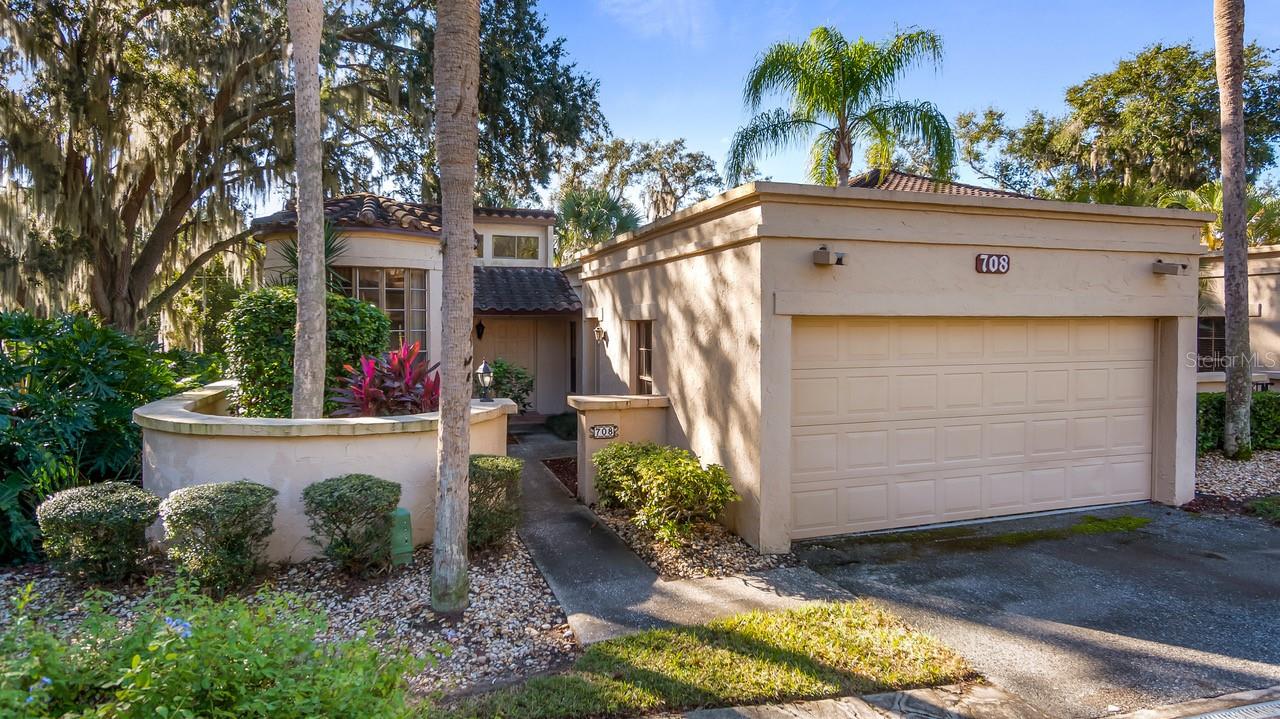 Welcome to resort-style living at its finest in this beautifully appointed, furnished corner condo located within the exclusive Mission Resort community. Surrounded by natural beauty and offering an impressive array of world-class amenities—including four exceptional restaurants and two championship 18-hole golf courses—this home delivers both relaxation and recreation. Nestled in the charming Santa Cruz community, this two-bedroom, two-bath residence is set amid lush, picturesque landscaping and exudes timeless Spanish-style character. From the moment you arrive, you’ll be captivated by your private courtyard and distinctive personal turret, creating a serene and inviting atmosphere. Inside, the home features tall ceilings, clerestory windows, and a light, calming color palette that fills the space with natural light. Terracotta tile flows gracefully from the foyer through the kitchen and living room, enhancing the home’s old-world charm. The spacious living and dining areas offer an ideal setting for entertaining, complete with a hidden wet bar for added sophistication. Both generously sized bedrooms feature en-suite bathrooms, providing comfort and privacy for owners and guests alike. Step outside to the expansive lanai, a secluded retreat perfect for outdoor dining, entertaining, or simply enjoying the peaceful surroundings of this enchanting community. Your two car garage offers additional storage space with a large area section off as a storage room. Mission Resort offers endless outdoor activities, with approximately 1,400 nearby lakes ideal for bass fishing, boating, and water sports. Whether you’re seeking a winter escape or a full-time residence, this home offers the perfect balance of privacy and social opportunities. Golf or social memberships are optional, and there are no age restrictions. Conveniently located just minutes from the Florida Turnpike, this condo provides easy access to Orlando’s world-class shopping, airports, and attractions. Both the Gulf and Atlantic beaches are within a two-hour drive, while nearby towns such as Mount Dora, Tavares, Clermont, and Eustis offer charming boutiques, waterfront dining, festivals, live entertainment, and year-round events. This exceptional condo promises a carefree, maintenance-free lifestyle in a peaceful rural setting. Don’t miss the opportunity to make this extraordinary home your own and start living the Florida lifestyle you’ve always dreamed of.