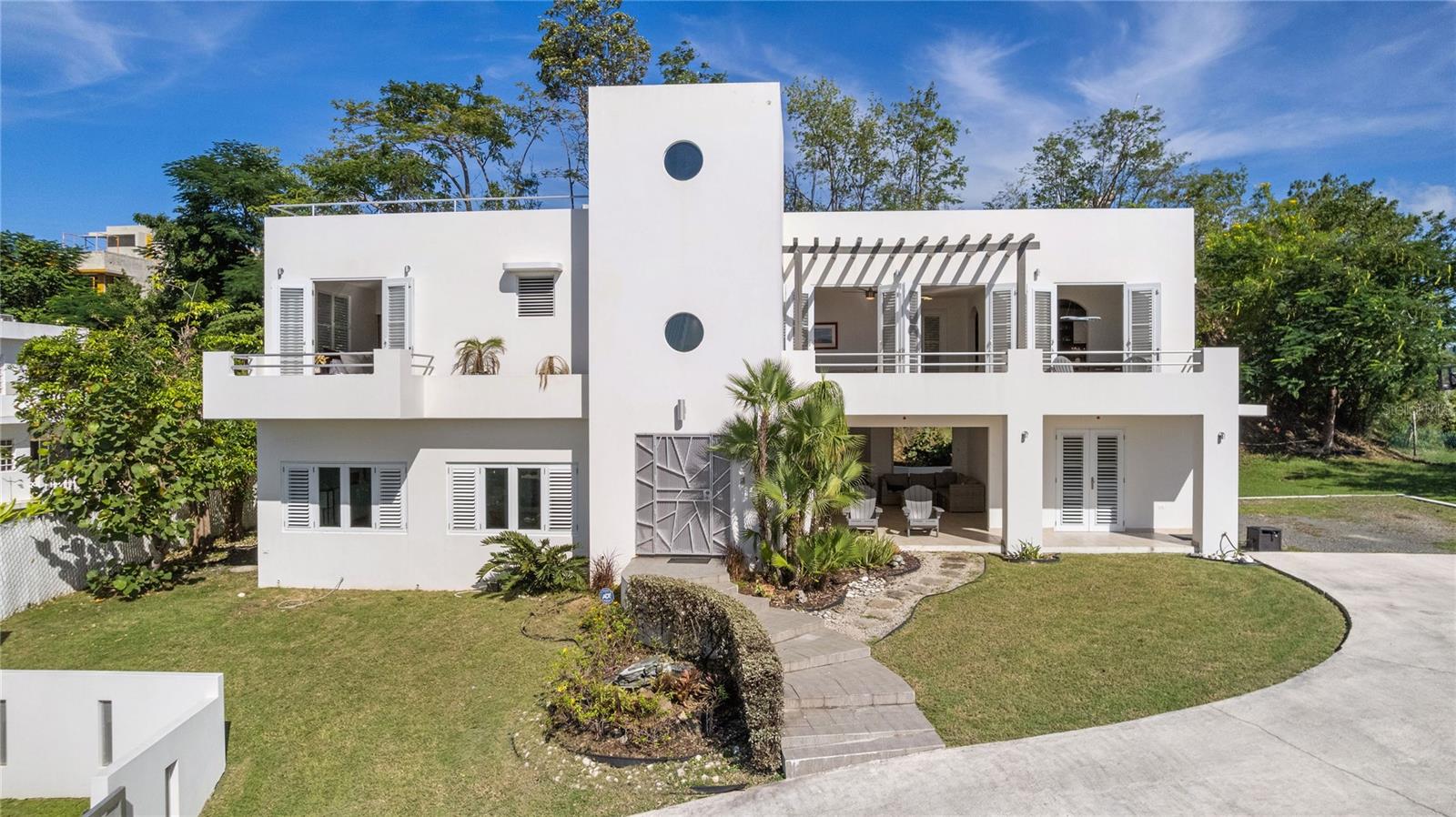 Perched above the coastline in one of Rincón’s most desirable areas, this contemporary 4 bedroom, 3.5 bathroom residence with a generous gross floor area of 3,871.23 sq ft captures the essence of relaxed Caribbean luxury. Sunlight pours through expansive openings, framing uninterrupted ocean views from the living and dining areas, while the gentle breeze flows effortlessly throughout the home. With multiple terraces overlooking the treetops and sea, every moment here feels connected to the natural beauty of Puerto Rico’s west coast.

Inside, the home features bright, open spaces designed for comfort and style. The primary suite offers its own private oasis, complete with an ensuite bathroom and a stunning ocean-view balcony—perfect for savoring quiet mornings or ending the day with the town’s iconic sunsets. The kitchen provides a functional space ideal for both everyday living and entertaining. Spacious guest bedrooms and well-appointed bathrooms ensure comfort for family or visitors.

Outdoors, the property continues to impress with covered terraces, open-air lounging areas, and landscaping that enhances the tranquil setting. From the lower patio and entertainment space to the rooftop terrace with panoramic views, this home is built to enjoy Rincón’s famous sunsets year-round.

Just minutes from beaches, dining, and surf spots, this is the perfect retreat for those seeking a lifestyle defined by ocean views, privacy, and timeless island living.
