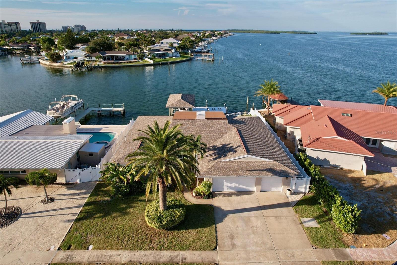 Exquisitely updated 4 bedroom 3 bathroom pool and spa home located in the prestigious Island Estates community of Clearwater Beach. Privately nestled near the end of a quiet and safe cul-de-sac, this tropical, modern home feels like you're on a permanent vacation! Breathtaking 180° open water views from a spacious and renovated backyard with entertaining space, boasting a large swimming pool and jacuzzi spa. Forget renting space for your boat! This sprawling home comes with 2 attached boat lifts! The first lift will support up to a 35’ boat and has a solid canopy to match the exterior of the home, and the other is a full drop- in mechanical DOCK currently outfitted for pulling up your jet skis, but can be easily be exchanged to support a variety of other water-crafts. Enjoy immediate access to the intercostal waterway, that leads directly into the beautiful Gulf of Mexico. 

Fish, paddle board, enjoy nature, watch boat parades, holiday fireworks AND the SUNSET right from your backyard. New Publix and shopping plaza with banking, shops and salons LITERALLY 2 minutes from your home, with a quick 5-10 minute car or bike ride to the white sands of Clearwater Beach itself! With Clearwater's fun neighboring town, Dunedin,  full of bars, restaurants, boutiques, and even nightlife- you'll never run out of things to do! 

The home boasts a completely NEW kitchen with state of the art appliances, new, LARGE LG flat screen TVs, updated bathrooms, updated electrical and plumbing, brand new flooring, new washer and dryer, and many LARGE energy efficient windows that allow you to take in all of the tropical views from inside, while cutting down on your energy bill! This home has been consistently updated and renewed by its loving owner, so you're sure to enjoy this slice of heaven without headaches! Come see this dreamy home in paradise today!