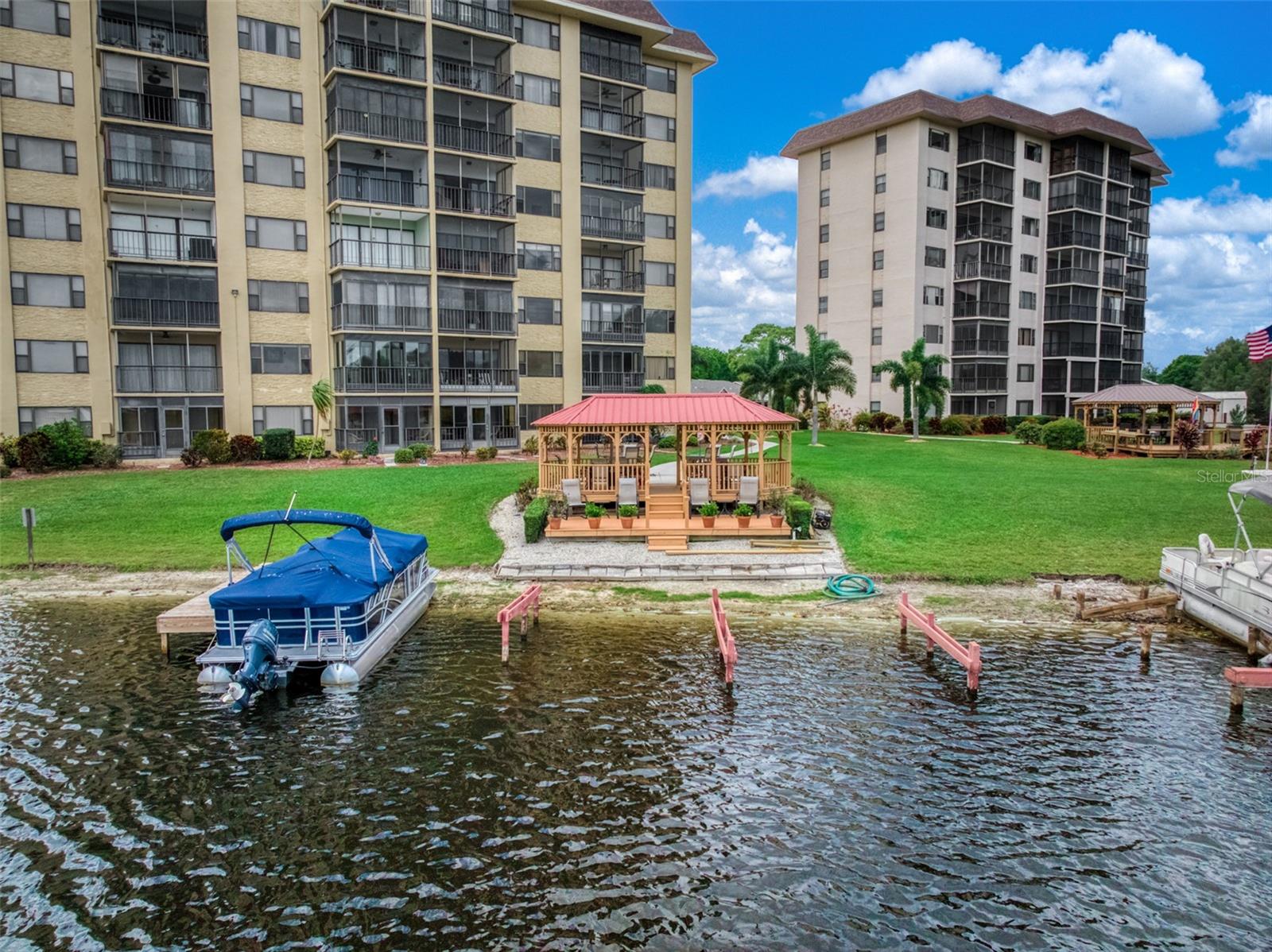 Being sold fully furnished, this well-maintained 2-bedroom, 2-bathroom second-floor condo in Lakeshore Tower One presents a rare opportunity for a move-in-ready lakeside retreat. From the moment you step inside, the space feels bright, open, and inviting, with natural light flowing through the living and dining areas. The home features newer flooring and updated bathrooms, creating a clean and refreshed interior. The living area extends into an enclosed Florida room an ideal space to relax and take in the peaceful views of the 517-acre Lake Grassy. Every detail comes together to create a setting that is easy to enjoy and ready for its next chapter. Residents of Lakeshore Tower One enjoy a low-maintenance lifestyle with amenities including a lakeside gazebo, sun deck, BBQ area, boat slips, elevator access, shared laundry, storage, and covered parking, with HOA conveniences such as water included. Ideally located near local shops, dining, and everything that makes lakeside living so desirable, this condo offers a unique blend of comfort, simplicity, and scenery. Schedule your private showing and experience it for yourself.