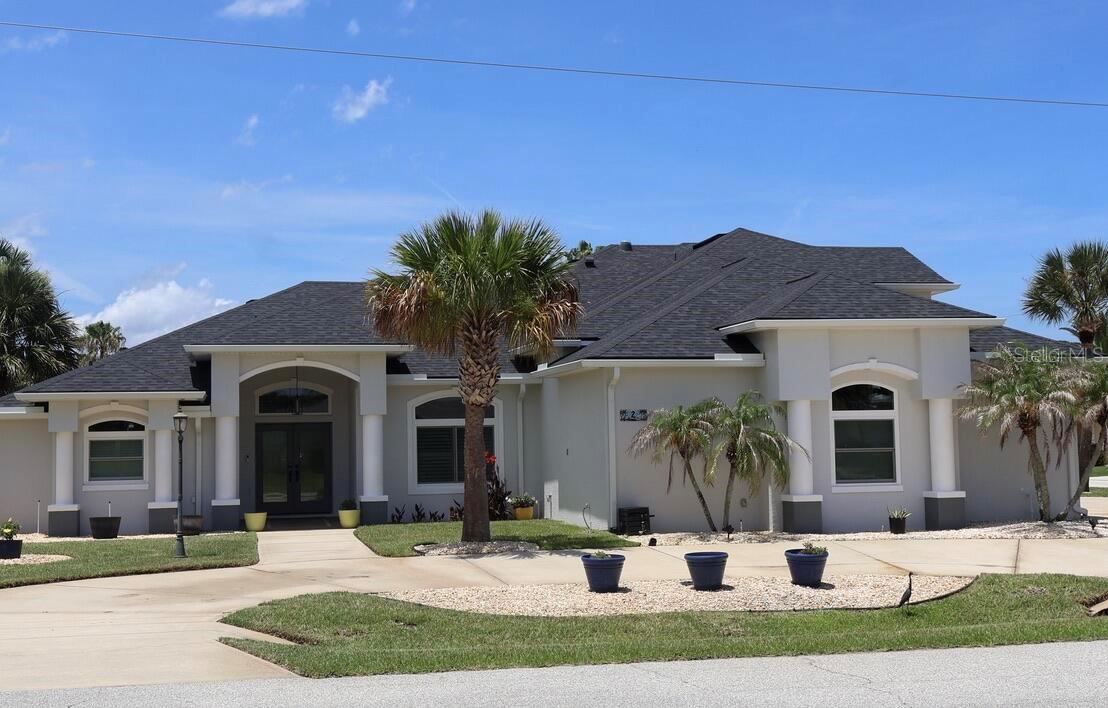 Welcome to waterfront living in the Sunshine State!  This 5-bedroom, 5-bath home with separate in-law suite is a rare find, great for large family gatherings and entertaining.  This corner lot home includes a 3-car garage with an automotive lift and two large driveways.  Nestled along the 120ft of canal front is the boat house with lift and West facing dock for sunset viewing.  It's a short boat ride to the Intracoastal waterway.  The heated saltwater pool, hot tub and pool deck are enclosed and includes outdoor entertaining at the built-in wet bar with beverage cooler, outdoor shower and separate pool 1/2 bath.  The home had a new roof, gutters and double pane storm windows within the last 3 years.  The kitchen was remodeled in 2025 and includes Frigidaire Professional Series appliances – 36” induction stove and oven, built in microwave/oven wall combo, large refrigerator and dishwasher.  There is a butcher block island, leathered granite countertops, large work sink with touch-less faucet, storage cabinets galore, a large walk-in pantry and built in wine cooler.  The master bedroom has French doors to the pool deck, a large master bath with separate vanities and closets, a freestanding tub and tiled shower with frameless glass door and rain head faucet.   The main level has tile throughout and fans in every room.  There is a separate formal dining area and eat-in area off the kitchen.  The large windows and sliders in the living room provide ample light and views of the pool and canal.  Off the living room is a separate entrance leading to a bedroom, full bath and separate sitting room with French doors to the pool deck.  To round out the main floor, there is a half bath, office and large laundry room with storage cabinets and sink.  Upstairs you will find three large bedrooms with ceiling fans and a full bath that includes a double sink vanity.  There is a whole house water softener, reverses osmosis at the kitchen beverage faucet, interlock and transfer switch panel for generator, new lift motor and slings, new landscape irrigation pump, fenced side yard, outdoor storage shed, new exterior lighting and exterior house and trim paint.  The home is minutes from beaches, parks, golf course, marina, shopping and dining.   All you need to do is unpack and start enjoying!