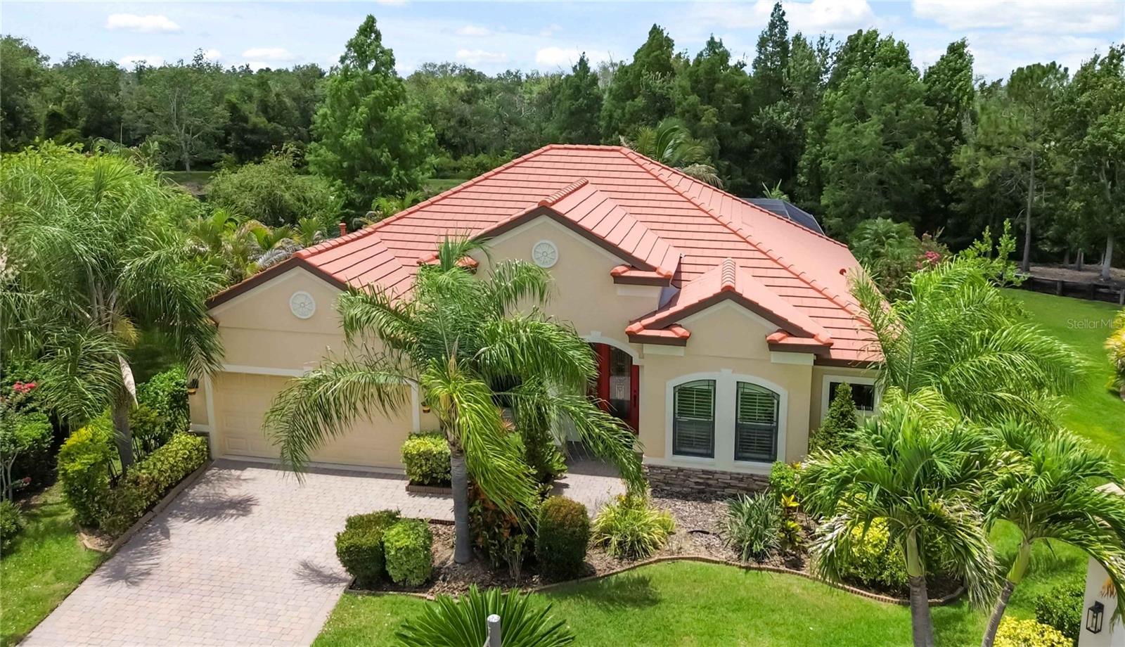 Tucked away in the gated, maintenance-free, lakefront community of Riva Trace, this thoughtfully designed 4-bedroom plus den, 3-bath home offers the perfect blend of comfort, privacy, and Florida living.

From the moment you enter, you'll appreciate the spacious feel created by soaring 12-foot ceilings, 8-foot doors, and an open layout accented with plantation shutters throughout. Porcelain tile flows through the main living areas, while the bedrooms provide the warmth and comfort of carpeting.

At the heart of the home is a well-appointed kitchen designed for both everyday living and entertaining. It features stainless steel appliances, natural gas cooktop w/hood, granite countertops, soft-close wood 42" cabinetry, a pantry, breakfast bar, built-in desk area, and a convenient butler's pantry with additional serving, storage  and glass front display space.

The private den, enclosed by glass French doors, makes an ideal home office, study, or flex space. Elegant details including crown molding and coffered ceilings enhance the formal dining room, living room, family room, and primary suite, while sliding glass doors invite natural light and seamless access to the outdoor living area.

The spacious primary retreat overlooks the pool and includes custom walk-in closet built-ins and a spa-inspired bath with dual vanities, granite countertops, a soaking tub, and a separate walk-in shower. Two guest bedrooms are tucked behind a pocket door and share a full bath, creating a private wing for family or visitors. A fourth bedroom sits adjacent to the pool bath, offering flexibility for guests or multigenerational living.

Outside is where this home truly shines. The screened lanai is designed for year-round enjoyment, featuring stunning travertine pavers, covered gathering spaces, an outdoor gas kitchen and bar w/sink and side burner, freeform pool with a tranquil water feature overlooking the lake and Preserve! Whether hosting friends or enjoying a quiet evening by the water, this outdoor setting feels like a private retreat.

Additional highlights include a laundry room with abundant cabinetry and utility sink, overhead garage storage, low HOA fees, and NO CDD fees.

Ideally located just minutes from shopping, dining, entertainment, SRQ Airport, and the Gulf Coast's beautiful beaches, this home offers the lifestyle so many are seeking in one of the area's most desirable communities. The location is truly exceptional, offering convenient access to Sarasota, its beautiful Gulf beaches, Siesta Key, Longboat Key, Lido Key and Anna Marie Island, Bradenton, and vibrant downtown St. Petersburg. You’ll also appreciate being just minutes from Sarasota-Bradenton International Airport and an abundance of premier shopping and dining at The Mall at University Town Center, Detweilers Market, Whole Foods, Fresh Market, Lakewood Ranch Main St and Waterside, Nathan Benderson Park and so much more!

Home is located in flood zone X, While pool and yard is located in AE