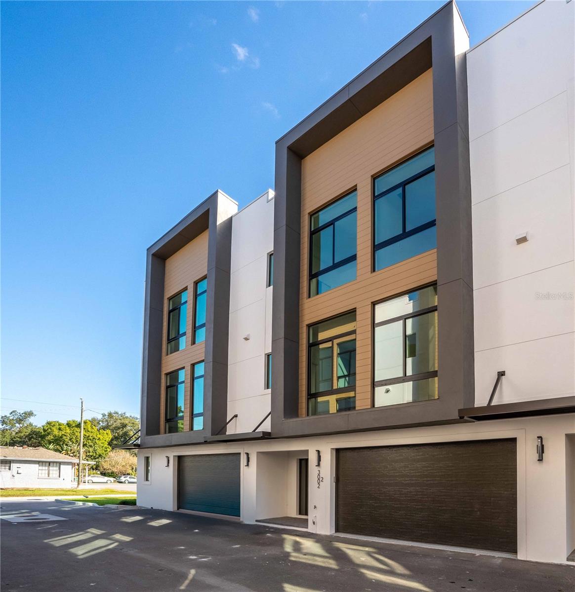 Architecturally striking, modern three-story townhome offering refined urban living in one of South Tampa's most desirable and walkable locations with 4,300 of total sq ft space. This 4-bedroom, 3.5-bath residence with a 2-car garage delivers exceptional construction quality, thoughtful design, and abundant natural light throughout. Built with ALL block construction, the home is engineered for durability and longevity, complemented by Trane HVAC systems and floor-to-ceiling PGT hurricane-impact windows and doors that provide security, energy efficiency, and a dramatic modern aesthetic. Wide-plank White Oak hardwood flooring flows throughout the living areas, enhancing the clean, contemporary design. The open-concept layout is ideal for both everyday living and entertaining, with balconies on every level and three covered Trex and pavered decks/porches that seamlessly extend the living space outdoors. Natural light pours in from multiple exposures, creating a bright and inviting atmosphere on each floor. The main living level features a private bedroom with a full ensuite bathroom, perfectly suited for multigenerational living, roommates, or students. All bedrooms are equipped with custom closet systems, maximizing storage and functionality. Additional highlights include an epoxy-finished two-car garage, elevator-ready design, guest and street parking availability, and a very low monthly HOA fee--a rare find for new construction in this location. Situated in an X flood zone (no flood insurance required) and zoned for A-rated schools, including Mitchell, Wilson, and Plant, the location is truly exceptional. Enjoy proximity to the University of Tampa, with walking distance access to SoHo, Hyde Park, hospitals, dining, and entertainment, offering the ultimate blend of lifestyle and convenience. A rare opportunity to own a modern, light-filled, and thoughtfully designed townhome in the heart of South Tampa.