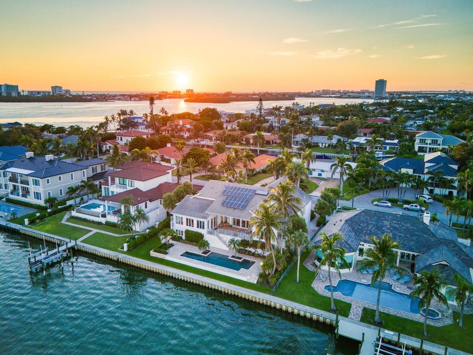 Set on the exclusive southern tip of Bird Key, this exceptional waterfront estate offers breathtaking, unobstructed views of Sarasota Bay, unmatched privacy, and a level of craftsmanship rarely seen. Designed and built by the owners with longevity and quality in mind, the home stands as a testament to timeless architecture and enduring construction. Elevated above floodplain with a ground level at 9.5 feet and a main living level at 16.1 feet, this residence spans 4,618 square feet under air on the main level, with nearly 10,000 total square feet of secure space, including a nine-car garage with EV chargers, an elevator, and an expansive ground-floor flex room that must be seen to be believed. Key features include four en-suite bedrooms, plus a bonus room with closet, ideal as a fifth bedroom or office. Soaring 22-foot ceilings and a light-filled open/split floor plan. Concrete block construction on 71 pilings driven 37 feet into bedrock. Impact-rated windows and doors, concrete tile roof and whole-house generator. Chef’s kitchen with water views, Thermador and Sub-Zero appliances, walk-in pantry, R/O system and water filtration throughout. Resort-style pool (recently renovated) overlooking Sarasota Bay, ready for your custom dock and boat lift. Striking entry with circular paver drive and beautiful tropical landscaping framing the property. With classic modern architecture, the interiors serve as a canvas for your personal design vision. Bird Key lifestyle where residents enjoy the option to join the Bird Key Yacht Club, offering boating, waterfront dining, tennis, fitness facilities, and a vibrant social calendar—from wine tastings and intellectual series to holiday celebrations and athletic events. Bird Key is positioned between the cultural energy of downtown Sarasota and the boutique shops and restaurants of St. Armands Circle, with Lido Beach just minutes away. If you're ready to have it all—privacy, luxury, location and waterfront living—schedule your private showing of this Bird Key gem today.