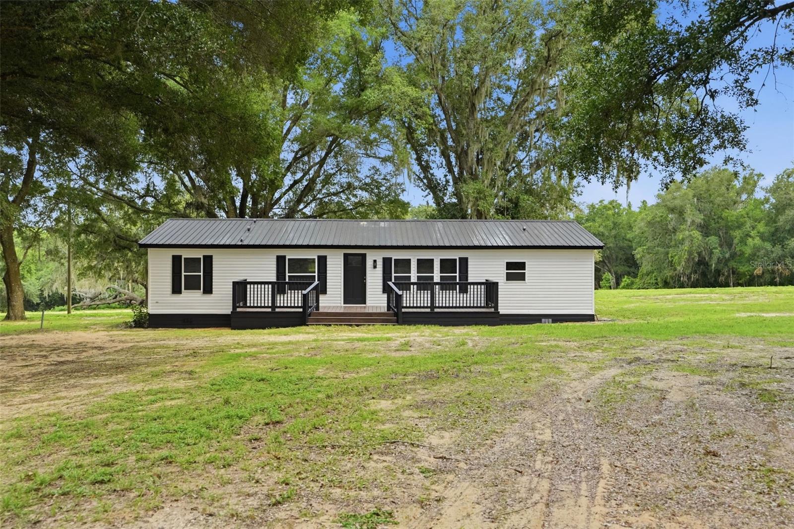Escape to the peace and privacy of country living with this beautifully remodeled 3- bedroom, 2- bath manufactured home nestled on 10 picturesque acres in rural Brooksville, FL. Thoughtfully updated from top to bottom, this move-in-ready home offers the perfect blend of modern comfort and wide-open space. 

No detail was overlooked in this total renovation, featuring a brand-new metal roof, new windows and doors, new HVAC/AC system, new tankless water heater, new laminate flooring throughout, all new beautifully designed primary bathroom and hall bath. Brand new kitchen cabinets along with all new LG stainless steel appliances. A brand-new gorgeous porcelain electric fireplace. The entire home has been freshly painted inside and out. New front and back decks spacious enough for all your entertaining purposes. 

Outside, enjoy endless possibilities across the 10 acres of rural land. Ideal for animals, gardening, recreational vehicles, farming or simply enjoying the privacy of the natural beauty of Brooksville, Florida. Whether you're looking for a homestead or a peaceful full-time residence, this property delivers room to roam and freedom to live the lifestyle you've been dreaming of.

Some photos are Virtually staged.