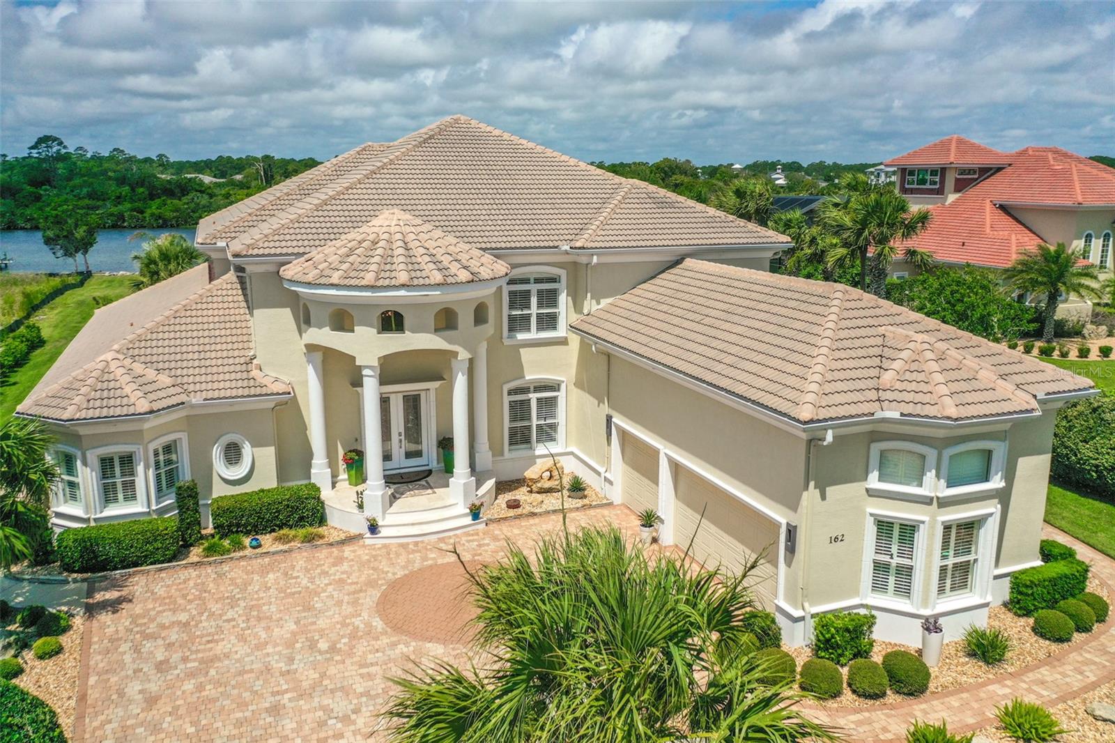 Looking to live the Florida dream in paradise? Then look no further! This amazing Intracoastal Waterway home is located in Island Estates, a 2 1/2 mile island with a gated community access to the quiet, soft coquina beaches that Flagler County is known for. The gated community offers a 24/7 gate staff and is part of Hammock Dunes. Enter through the beautiful double doors to find a breathtaking view of the Intracoastal Waterway and beautiful lanai and pool area. The downstairs master bath offers offers a two-person jetted bath tub and large shower with two shower heads and body spray jets. The large kitchen is open to the family room and offers Viking, Sub Zero and Miele appliances. Head upstairs taking the stunning staircase to find four large guest bedrooms, the amazing bonus room and 1/2 bath. The outdoor living space is a place to relax and enjoy the beautiful sunsets, pool and Intracoastal view. The outdoor kitchen offers a new 42" Alfresco grill, double gas burner, refrigerator and large Alfresco sink. Enjoy boating? Then no doubt you will enjoy the upgraded 10,000 pound, 30 foot boat hoist and covered dock with a second covered pontoon boat slip.  Membership to the Hammock Dunes Club is available but not required. The Oceanfront Hammock Dunes Club is ranked as an "Emerald Club of The World"  Enjoy delicious meals or a quick snack in one of the 3 OCEANFRONT dining rooms or at the quaint clubhouse at the Creek Course. Hammock Dunes has 2 18 Hole golf courses by Rees Jones and Tom Fazio.  Hammock Dunes Club offers an OCEANFRONT Heated Pool, Kid's Splash Pad, Hot Tub, numerous community beach walkovers so you can enjoy the quiet, soft coquina beaches Flagler County is known for, A 5,000 SF Fitness Center, Tennis, Pickleball, OCEANFRONT Bocce Ball, OCEANFRONT Croquet, in addition to year round Social Events. Flagler County is located on the Atlantic, Central Florida Coast and is just 1 hour to Jacksonville or Orlando and 30 minutes to Daytona Beach or Saint Augustine. Come see why the Locals call it "Paradise" and why visitors return year after year. Schedule an appointment today and begin living the Florida dream life!