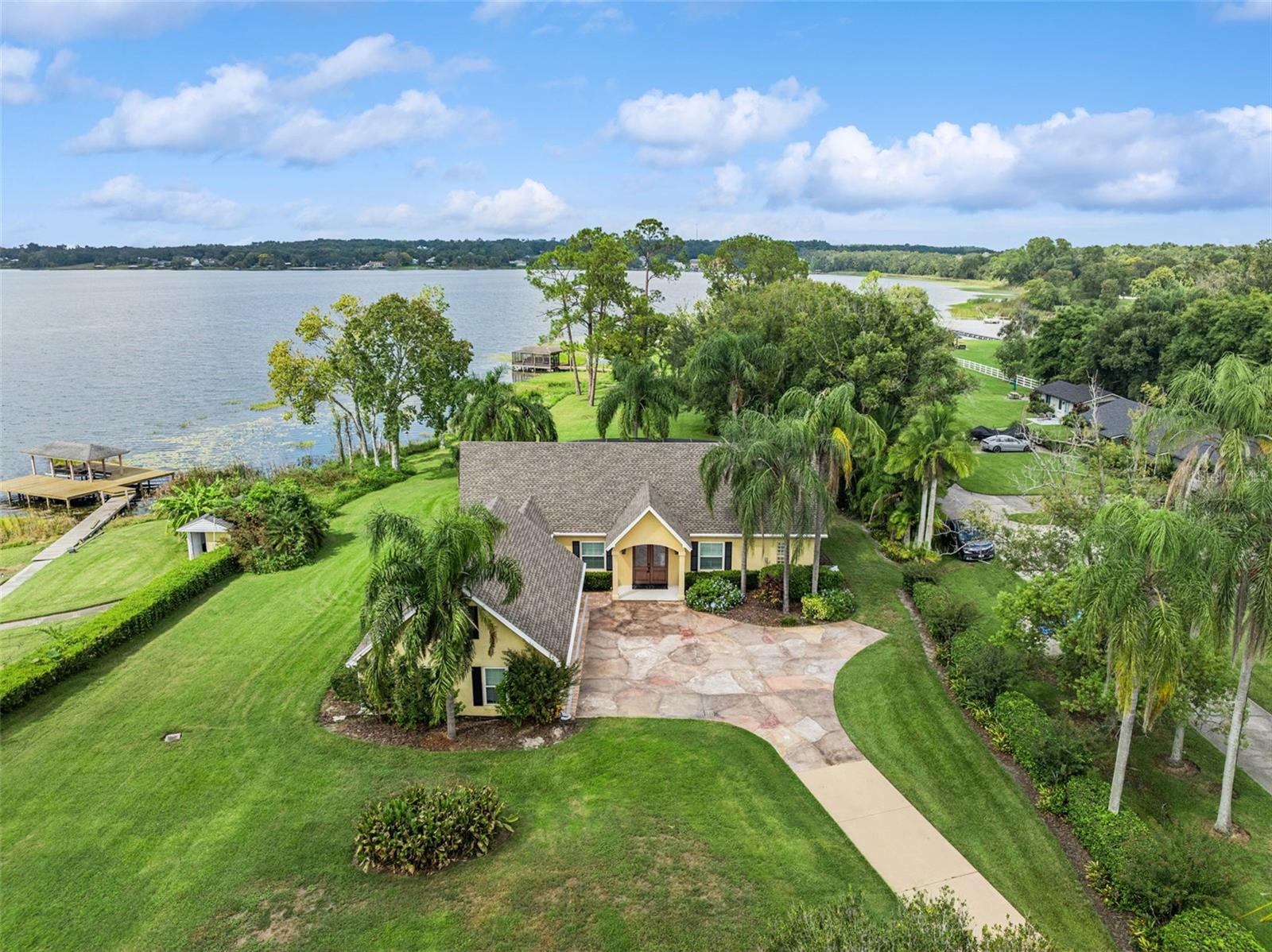 WATER FRONT LAKE HOUSE WITH BOAT HOUSE!!!  Here is a Rare opportunity to own on Lake Ola.  This stunning waterfront property features its own screened-in boat house with a boat lift, perfect for evenings on the water. This custom home overlooks a pristine swimming pool and Lake Ola, a striking 426-acre spring-fed jewel. Main level highlights include an exceptional primary suite with a bonus room accessed directly from the primary bath. The home gleams with plantation shutters and numerous tasteful finishes. Upstairs, you'll find two additional bedrooms (one with a private balcony overlooking the lake) and a welcoming second living area for guests. A standout is the bonus room above the garage, an unexpected hidden gem. This is a rare lakeside jewel on Lake Ola, your waterfront dream awaits. 2024 Roof, 2018 Windows and Doors. 2013 and 2016 AC units. Security cameras on site (by appointment only please) property is occupied.