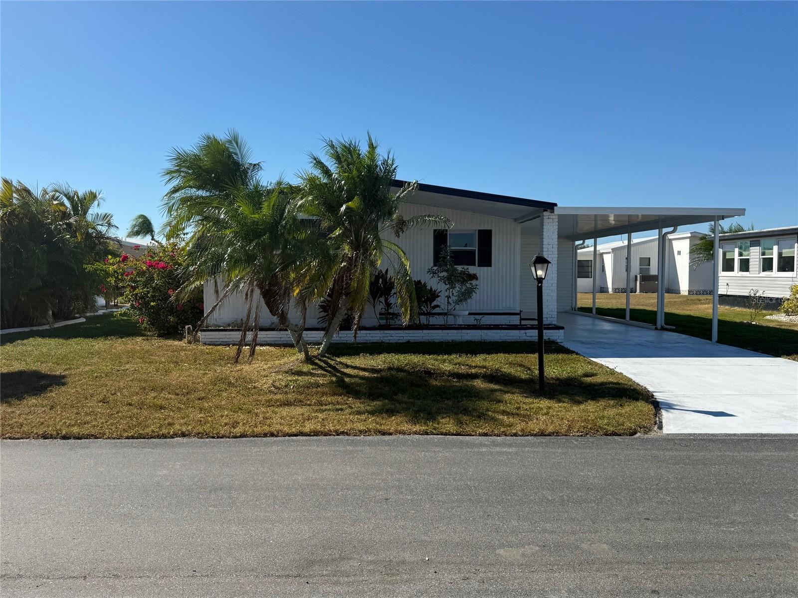 This two-bedroom, two-bathroom home has already undergone some remodeling and is ready for your own ideas and creative touches. The kitchen features a center island that opens up to the living room. The living room then leads to a spacious, glass-enclosed Florida room, which includes a front awning and a door to the carport. The primary bedroom boasts a generous walk-in closet, while the guest bedroom offers a double closet for additional storage. The home features hardwood flooring, a new roof, new carport, extended utility room and is being offered furnished. La Casa offers the ultimate lifestyle on Florida’s Gulf Coast is located between Sarasota and Fort Myers.  It is convenient for shopping, sightseeing, golfing, fishing, and boating, as well as the culture and elegance for which Southwest Florida is noted. Residents and visitors enjoy the warmth of Southwest Florida winters in a relaxed and unhurried environment far removed from the hustle of Florida’s east coast. You’ll be surrounded by hundreds of palms reaching for the sky and beautiful mature lush landscaping which demonstrates the utmost level of care our property receives from residents and management.  Wireless Internet (Wi-Fi) is available at the Clubhouse, Activity Building, and Recreation Hall area where our pools & spas are located, so you can catch some rays while you catch up on your email! Sound enticing? La Casa is a friendly, family community. You will be away from the hustle and bustle except when you want to be part of it. When you leave our gates, North Port is only 1.5 miles from the city center, where you will find every kind of retail store and service you could need. Come for a visit to this self-contained oasis and see for yourself why La Casa is the ultimate destination for both snowbirds and year-round.