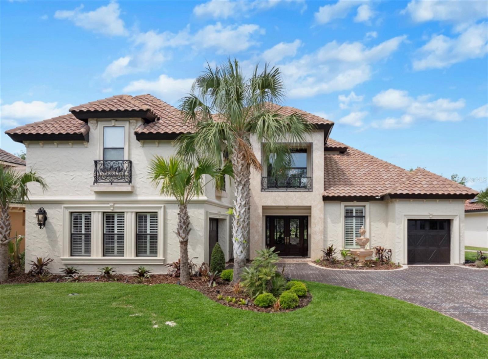 Designed for a luxurious lifestyle, this French Mediterranean Mini Mansion has just undergone an extensive design change and renovation. With its wrought iron Juliet Balconies, marble stoops, oversized trim, French Scroll corbels and the Old-World stucco with custom color finish is truly a timeless classic. A Versailles inspired fountain greets you as you enter the courtyard. The paver driveway has been custom hand stained for a cobblestone look and feel. New exterior lighting to accentuate the refined luxury and superior craftsmanship. As you step inside, prepare to experience the classic charm of Olde World Grandeur, influenced by enduring 16th century European style architectural design. The residence boasts intricately carved wood trim along the ceiling, complemented by recessed lighting. Arched doorways and carved wood columns throughout the home. Over 3500 square feet of Italian and Turkish marble. Superior installation of the harlequin designs of the marble that have reined throughout time as a symbol of its timeless elegance and resurgence. Most recent on the Versace and Louis Vuitton runways. The home features four bedrooms and five and half baths. The main level includes a formal dining room with intricate designed cabinetry, grand living room with fireplace, full Chef's kitchen, keeping room with martini bar and the majestic master suite. The master suite abounds with grandeur. His and her custom closets with dressing room appeal. A meticulously designed shower with floor to ceiling marble, multiple shower options and seating to take in all in. Double vanities and French chandeliers. Leaving the suite through an amazing solid wood arched door, ascend the marble staircase to the second floor which includes a second master suite complete with jacuzzi tub and walk in shower. Bedroom three includes private full bath. The fourth bedroom/mother-in-law suite is complete with full bath newly installed walk-in shower, kitchenette, walk-in closet, two utility closets and private computer work desk area. All recently renovated. The area of this space is 748 sq ft.  The suite now serves as an advanced theater room, featuring nine electronic theater-style chairs, an HD projector system, and nine Eclipse speakers, remote dropdown screen. Add a Murphy bed and this space become both, an overnight guest suite and theater room.  Also on second level is a loft-office (16' x 19') with magnificent view of the lower level and pool area. Guaranteed to take the stress out of any workday. End your day with a walk outside to the resort style saltwater pool, a beautiful outdoor Viking kitchen with six burner grill, wet ice maker, and refrigerator. The screened in Lani is outfitted with custom designed seating featured in Restoration Hardware’s Sedona collection for 2026. The listed price covers this collection, which was made specifically for this home’s use. Other recent upgrades include two new HVAC units, gas pool heater, new bar appliances, new landscaping, including sod, new irrigation valves and sprinkler heads. This masterpiece is in the Plantation Bay Private Golf Community. Membership includes 45 holes of golf, fitness center, pickle ball, tennis courts, pool and newly built breathtaking clubhouse. If you have a love for Oide World Grandeur and timeless elegance, this could be your "Happy Place."