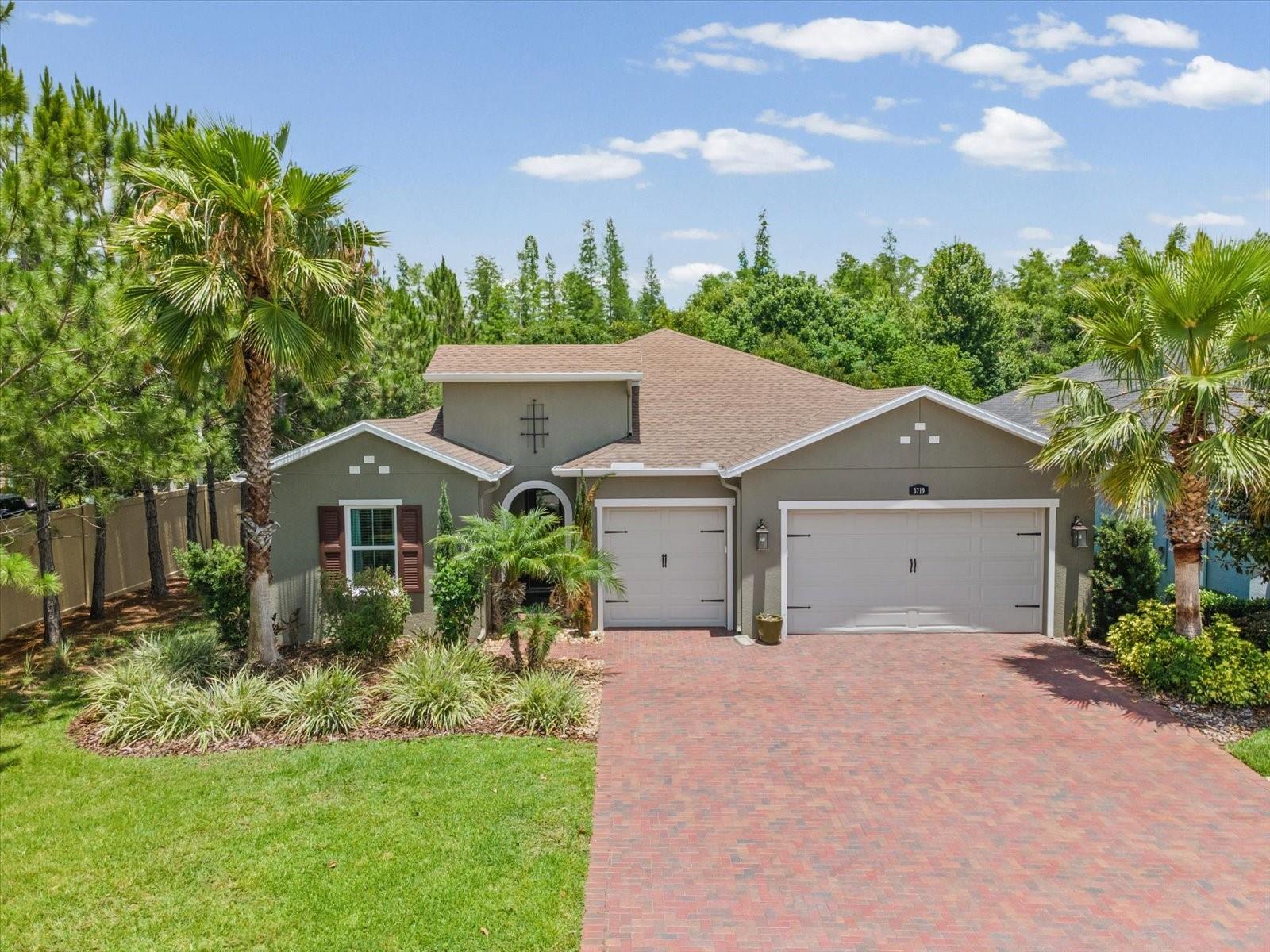 WOW! From the moment you arrive at this impeccably maintained CalAtlantic Magnolia floor plan, it’s clear this is the home you’ve been waiting for. A sweeping paver driveway leads to the stunning stucco façade, lush tropical landscaping, landscape lighting, and charming arched entry that hints at the elegance within. Step inside to a grand foyer crowned by a soaring tray ceiling, setting the tone for the thoughtfully designed split-bedroom floor plan offering privacy for all.
The heart of the home is a showstopping gourmet kitchen featuring rich dark raised-panel cabinetry with crown molding, gleaming Quartz countertops, and a large center island with a double stainless sink and statement pendant lighting that doubles as functional art. Stainless steel appliances include a side-by-side refrigerator, wall oven, microwave vented to the outside, dishwasher, and gas cooktop designed to make every meal an occasion. A stylish tile backsplash, walk-in pantry, and open flow into the great room complete this exceptional space.
The sun-filled great room showcases a built-in fireplace, abundant windows, and direct access to the lanai and spa, creating the seamless indoor/outdoor Florida lifestyle buyers dream about. The dining room is equally inviting, with sliding glass doors opening to the lanai.
Retire each evening to the luxurious owner’s suite featuring a generous sitting area bathed in natural light from triple windows adorned with Plantation shutters, all beneath an elegant tray ceiling. The beautifully appointed ensuite bath offers separate vanities with Quartz countertops and undermount sinks, a large walk-in shower tiled floor-to-ceiling with a built-in bench and contrasting Listello detailing, a private water closet, and a deep garden soaking tub created for relaxation and escape. The expansive dual walk-in closet is a dream organizer with custom shelving, drawers, shoe racks, and abundant hanging space to accommodate every wardrobe with ease.
Bedroom two is privately situated off the foyer with its own ensuite bath, while generously sized bedroom three is adjacent to a beautifully appointed third bath. Behind glass French doors, the den/office creates the perfect professional or student retreat with new tile flooring, custom built-ins, a built-in desk with upper and lower cabinetry, granite countertops, and a ceiling fan. The dedicated laundry room is both functional and beautifully organized with upper and lower cabinetry, washer and dryer, utility sink, and granite countertop workspace.
Your outdoor paradise awaits. Designed for Florida’s year-round entertaining lifestyle, the screened lanai showcases a dramatic rock sheer-descent waterfall flowing into the heated spa featuring 10 jets, wraparound bench seating, and LED lighting, all surrounded by a travertine pool deck. A stacked stone wall with a built-in fireplace, outdoor grill, granite bar countertop, and lush tropical backyard framed by elegant wrought iron fencing create an extraordinary private retreat. Mature mango, orange, avocado, and breathtaking Hong Kong Orchid trees complete the resort-style setting. Additional upgrades include a tankless gas water heater. Move-in ready and meticulously maintained, this exceptional home is located in the highly sought-after Promenade at Lake Park within the desirable Steinbrenner High School district. Schedule your private showing today and discover the elevated lifestyle awaiting at 3719 Wicket Field Road.