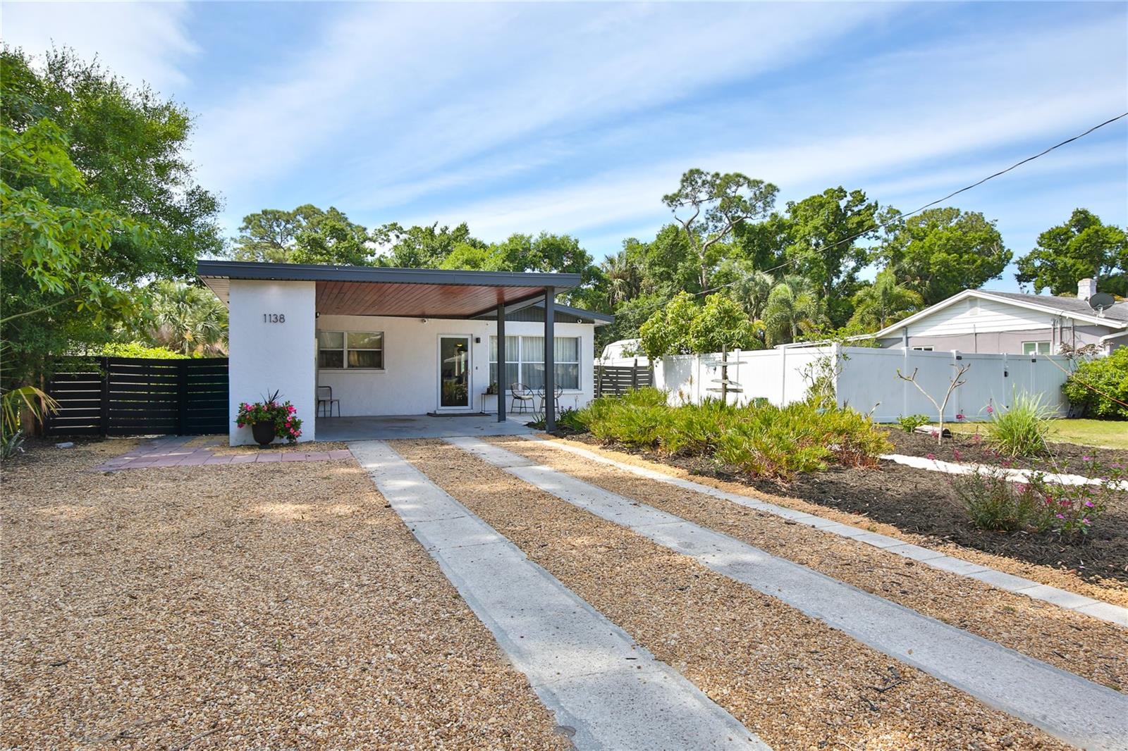 Nestled in the heart of Sarasota, this charming 1950’s ranch is an opportunity to own a tastefully remodeled home within the city limits of Indian Beach. This home has an unusually pleasing flow with a split bedroom plan and expansive common space including the kitchen and dining area.  To the front of the house, there are two adjacent bedrooms: the first guest bedroom and guest bath and the primary bedroom with en suite bath. The primary bedroom connects to the laundry room which has a passthrough door to the rear hallway of the home, taking you to the 2nd guest bedroom. There is a new single vehicle oversized carport built to current hurricane standards along with an incorporated bank of storage closets and an electrical car outlet. The sun-dappled private fenced yard conveys a feeling of great peace.  The front yard has a Zen garden.  The back yard is bordered by lush plantings offering privacy and space to enjoy a barbeque, bonfire or relaxation. In the front, the carport and oversized driveway provide plenty of room for parking of cars, RVs, toys, boats, etc. Bonus to the new owner is the Tesla Solar System including two new power walls, 24 panels (16 are only one year sold). Peace of mind with one year old roof, relined pipes including some new PVC pipes, partial concrete construction, masonry walls and in flood zone X and X500 and hurricane panels. There are no deed restrictions or HOA fees. Easy commute to downtown, beaches, colleges, Ringling, airport, restaurants, shopping at our upscale UTC mall, and much more. Indian Beach is known for its historic character, mature tree-lined streets, and proximity to the vibrant cultural scene of downtown Sarasota. Being within the city limits allows for the flexibility of weekly rentals making it a viable investment opportunity. City-owned Water Tower Park is a short walk away offering a great place to absorb nature, ride bikes, play frisbee golf, picnic, etc. Just a bike ride away you will find the Rosemary District, a hip neighborhood with cafes and modern bistros. Easy bike ride to explore art galleries, fine dining, botanical gardens, and all the culture Sarasota has to offer. Short distance to the new Bay Park with 53 acres for your walking, playing and picnicking pleasure.