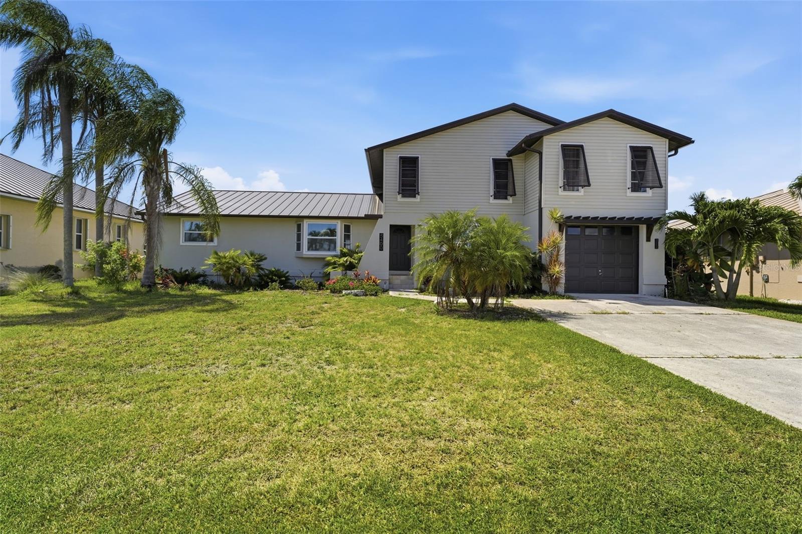 Welcome to 5400 Almar Drive, a rare waterfront gem situated on a quiet dead-end street in one of Punta Gorda Isles' most desirable sailboat-access neighborhoods. Offering exceptional boating convenience, this property provides quick access to Charlotte Harbor via Buckley's Pass, putting world-class boating and fishing right at your doorstep. Boaters will appreciate the impressive waterfront setup featuring over 70 feet of concrete seawall, a 10,000-pound boat lift, and a concrete dock ready for your next adventure. Even better, the seawall is maintained as part of the Punta Gorda Isles canal system, providing owners with added peace of mind and one less major expense to worry about.  This beautifully updated home offers 3 bedrooms, 2 bathrooms, and a floor plan unlike the typical PGI layout. The oversized primary suite is truly one-of-a-kind, featuring an expansive bedroom, a private sitting area, and additional flex space perfect for a home office, reading room, fitness area, nursery, or personal retreat.  The primary suite's most captivating feature is its private observation deck overlooking the tropical surroundings and waterfront community. Imagine starting your mornings with coffee as the sun rises or unwinding in the evening with a glass of wine while enjoying Southwest Florida's spectacular sunsets. It's the perfect place to relax, recharge, and enjoy the lifestyle you've worked so hard to achieve. After experiencing this private retreat, you may find yourself asking, "Why would I ever want to leave?"  Recent updates and improvements include a beautifully remodeled kitchen featuring quartz countertops, stainless steel appliances, updated cabinetry, luxury vinyl plank flooring, remodeled bathrooms, fresh interior and exterior paint, and a newer transferable metal roof. The plumbing has been updated, and recessed lighting, ceiling fans, and light fixtures have been thoughtfully replaced throughout the home. Several windows and doors have also been upgraded, including the front bay window and windows in the family room and living room.  Additional improvements include a new air conditioning system installed in 2023, a completely new irrigation system installed in 2022, including a replacement boat lift and updated pool cage screening and hardware. Natural light pours throughout the home thanks to a beautiful skylight, creating a bright and inviting atmosphere.  Step outside to your spacious screened pool area, complete with a hot tub, fenced backyard, and lush, meticulously maintained landscaping. Whether entertaining family and friends or enjoying a quiet evening under the stars, this outdoor oasis embodies the very best of Florida waterfront living.  The extra-deep two-car garage provides abundant storage space and features a rear garage door for convenient access to the backyard and waterfront area. 
Located just minutes by boat to Charlotte Harbor and only a short drive to downtown Punta Gorda's restaurants, shopping, parks, marinas, and waterfront attractions, this exceptional property combines luxury, convenience, and the ultimate Southwest Florida boating lifestyle.