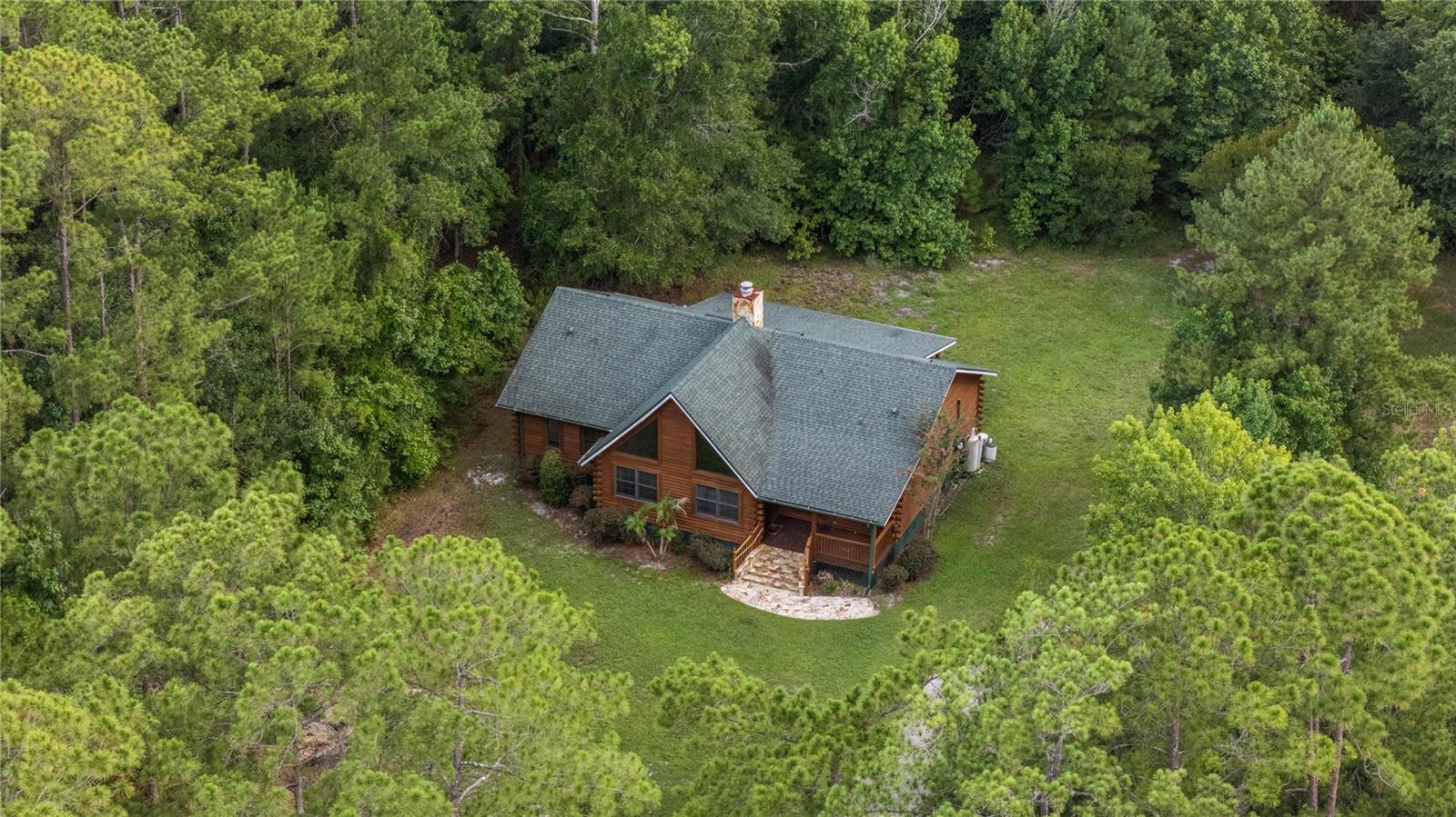 Welcome to 712 Mallard Drive, an exceptional five-acre parcel tucked within the equestrian community of Seminole Estates, where rustic architecture, remarkable privacy, and boundless potential come together in one of the community's most coveted locations. Set along sought-after Mallard Drive, this property enjoys an extraordinary backdrop that few homes can ever replicate. Bordering the vast Black Bear Wilderness Area, the rear property line opens to hundreds of thousands of acres of protected natural landscape, creating an unrivaled sense of space, privacy, and permanence. With the wilderness trailhead located just down the street, hiking, horseback riding, wildlife viewing, and endless outdoor recreation become part of everyday life.

Behind a private gated entry and at the heart of the property, the authentic log cabin captures the warmth and character that only natural timber construction can provide. Soaring cathedral ceilings accented by exposed wood beams create an impressive sense of volume, while wood plank ceilings and rustic finishes establish an atmosphere that feels both inviting and timeless. The three-bedroom, two-bathroom floor plan offers comfortable everyday living while preserving the cabin's distinctive architectural appeal. The kitchen is surprisingly spacious for this cozy 2,000 square foot residence and the oversized front and back porches create perfect spaces to take in the quiet and scenic surroundings.

Beyond the existing residence, the true opportunity lies in the land itself. Five usable acres provide exceptional flexibility to create the estate you've envisioned. Whether expanding the current home, constructing a new luxury residence, adding detached garages, workshops, barns, stables, guest accommodations, or creating a premier equestrian property, the possibilities are as expansive as the setting. Complementing the property's future potential, newly completed multi-million-dollar custom homes next door reinforce the long-term desirability and value of this exceptional location.

A newly installed private gated entrance creates a memorable arrival while enhancing privacy and security. Private well and septic utilities further add to the property's appeal by providing independence from municipal services and helping keep ongoing utility costs remarkably low.

Rarely does a property offer the opportunity to enjoy the character of an authentic log cabin today while providing the land, location, and surrounding values to create an extraordinary legacy estate for tomorrow. At 712 Mallard Drive, nature becomes your backyard, privacy becomes your lifestyle, and the possibilities are limited only by your imagination.