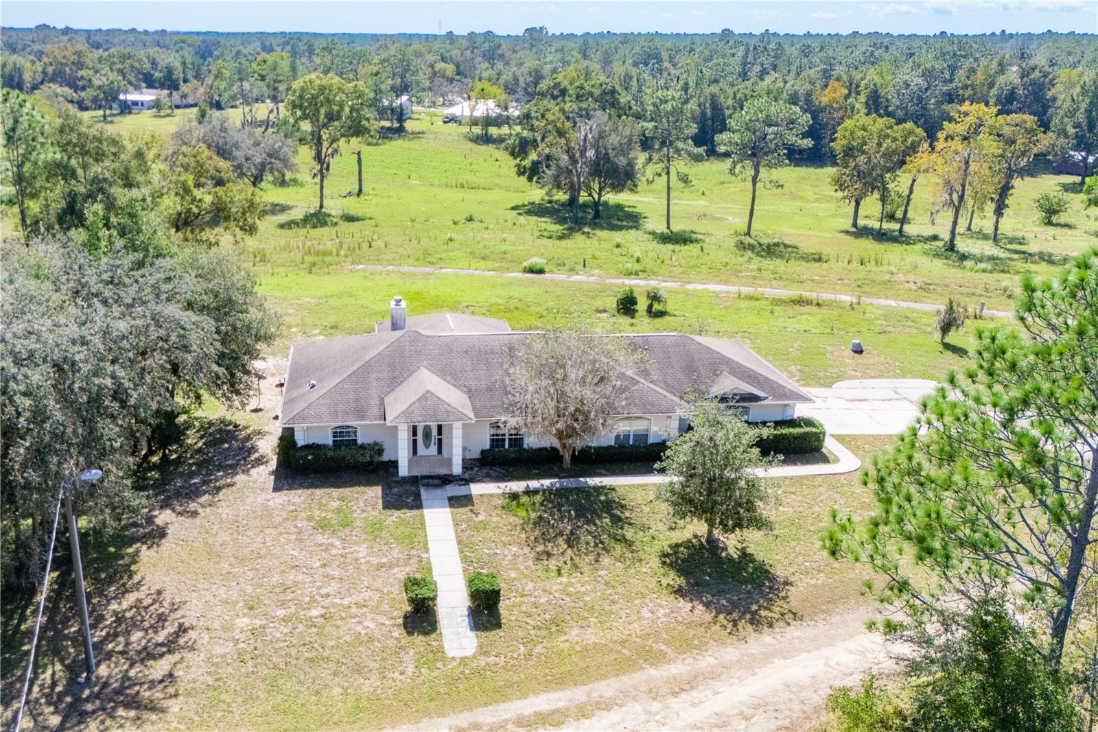 BRAND NEW AC UNIT -2026 A/C system installed! Seller is also offering a CREDIT TOWARD A NEW ROOF.
Lovingly maintained 3-bedroom, 2-bath home tucked at the end of a quiet dead-end road, offering outstanding privacy and beautiful natural surroundings. This property includes the main homesite plus an additional wooded 0.31-acre lot next door, preserving the tranquil setting and providing extra space or future opportunity.

Enjoy wide, unobstructed views of the open grounds of the former golf course—no longer in service—creating a rare sense of space and serenity.

Inside, the home shines with character and care. Light-filled living areas flow into a cozy sunroom, perfect for morning coffee or evening relaxation. The screened porch invites you to soak in the peaceful breezes and natural views. Both bathrooms retain their classic overhead red heat lamps, a charming and functional vintage feature.

A 2-car garage plus golf cart parking ensures convenience and storage, while the brand-new water heater adds peace of mind.

Whether you’re seeking privacy, a connection to nature, or room to grow, this well-loved home is a rare find in Williston Highlands—ready for its next chapter!