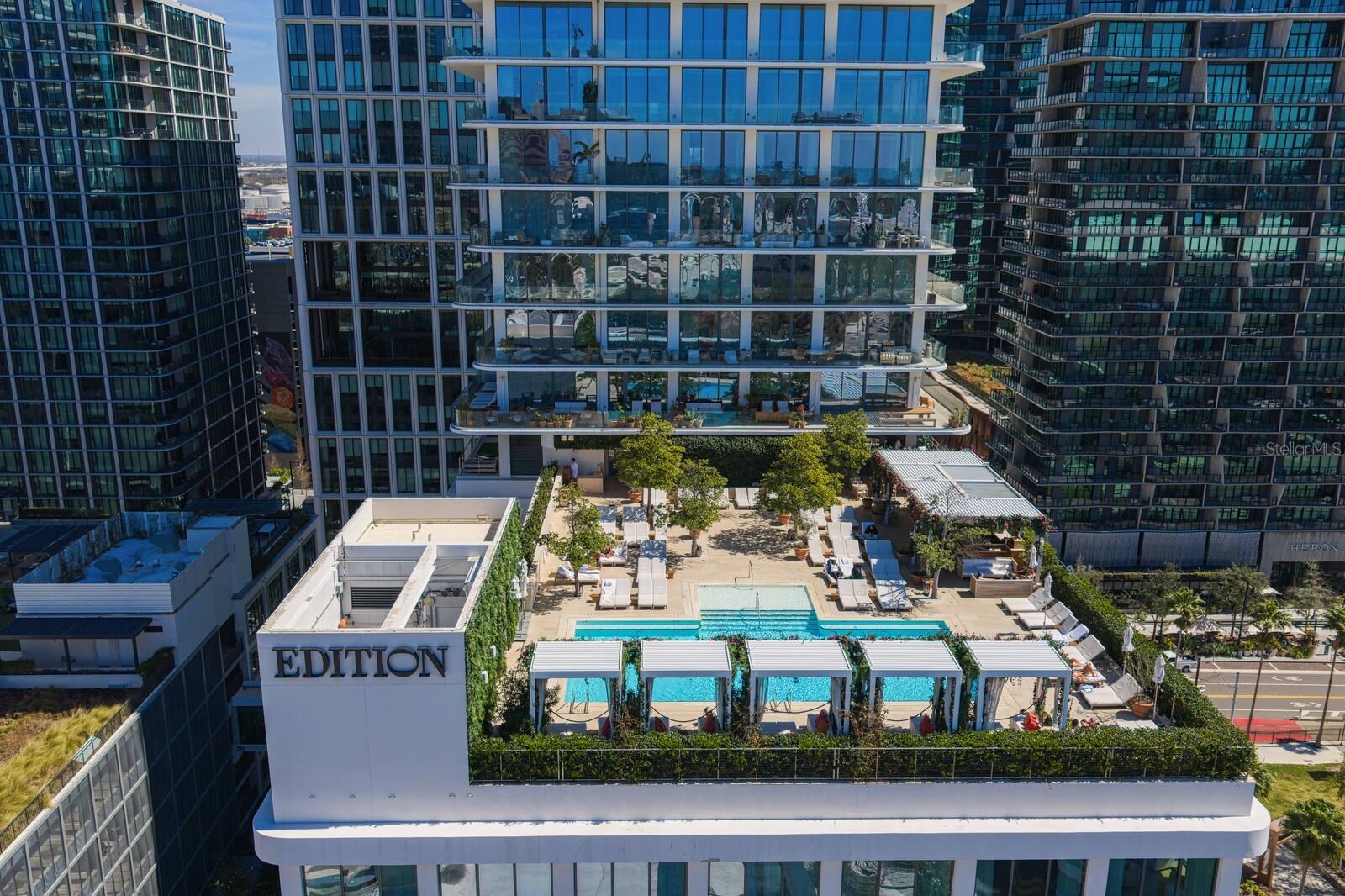 One or more photo(s) has been virtually staged. Welcome to Residence 1502 at The Tampa EDITION, an exceptional luxury corner home rising above Tampa’s only five-star hotel in the heart of
Water Street Tampa. Completed in 2022, this boutique residential collection offers just 38 private residences, delivering rare exclusivity, privacy, and
service. This stunning 3-bedroom, 3 full and 1 half bath residence spans approx. 3,014 sq ft of refined interior living space, with over 4,094 total sq ft
including an expansive wraparound terrace. Ten-foot ceilings and floor-to-ceiling windows frame sweeping views of Tampa Bay, the downtown skyline,
and the vibrant Water Street district, filling the home with natural light. The open-concept layout seamlessly connects the living and dining areas,
complemented by a den/office ideal for flexible living. Finishes include 10” wide-plank Grato white oak hardwood flooring, stone and tile accents, and
custom Molteni Italian millwork throughout. The chef’s kitchen features a striking Polaris White marble waterfall island, Gaggenau gas cooktop and
ovens, wine cooler, Miele vent hood, and premium appliances. The spa-inspired primary suite offers a serene retreat with 24x24 Polaris marble, a
deep Kaldewei freestanding soaking tub, and bespoke Molteni cabinetry. Custom closets and motorized window shades with blackout features
enhance comfort throughout. The post-less glass-railed terrace creates a seamless indoor-outdoor experience, ideal for entertaining or quiet mornings
overlooking the water and city. The home includes 3 assigned covered garage parking spaces, a dedicated storage unit, and EV charging station.
Residents enjoy a private residential entrance, lobby, elevators, concierge, and residents-only gym and lounge, along with access to the Tampa
EDITION’s rooftop pool, spa, fitness center, valet, and seven curated dining venues including Michelin-star chef, John Fraser, -driven experiences.
Located within the WELL-certified Water Street Tampa community, offering 24-hour security and walkability to the Riverwalk, waterfront parks,
shopping, dining, arts, and entertainment. 1000 Water Street #1502 represents the pinnacle of downtown Tampa living.