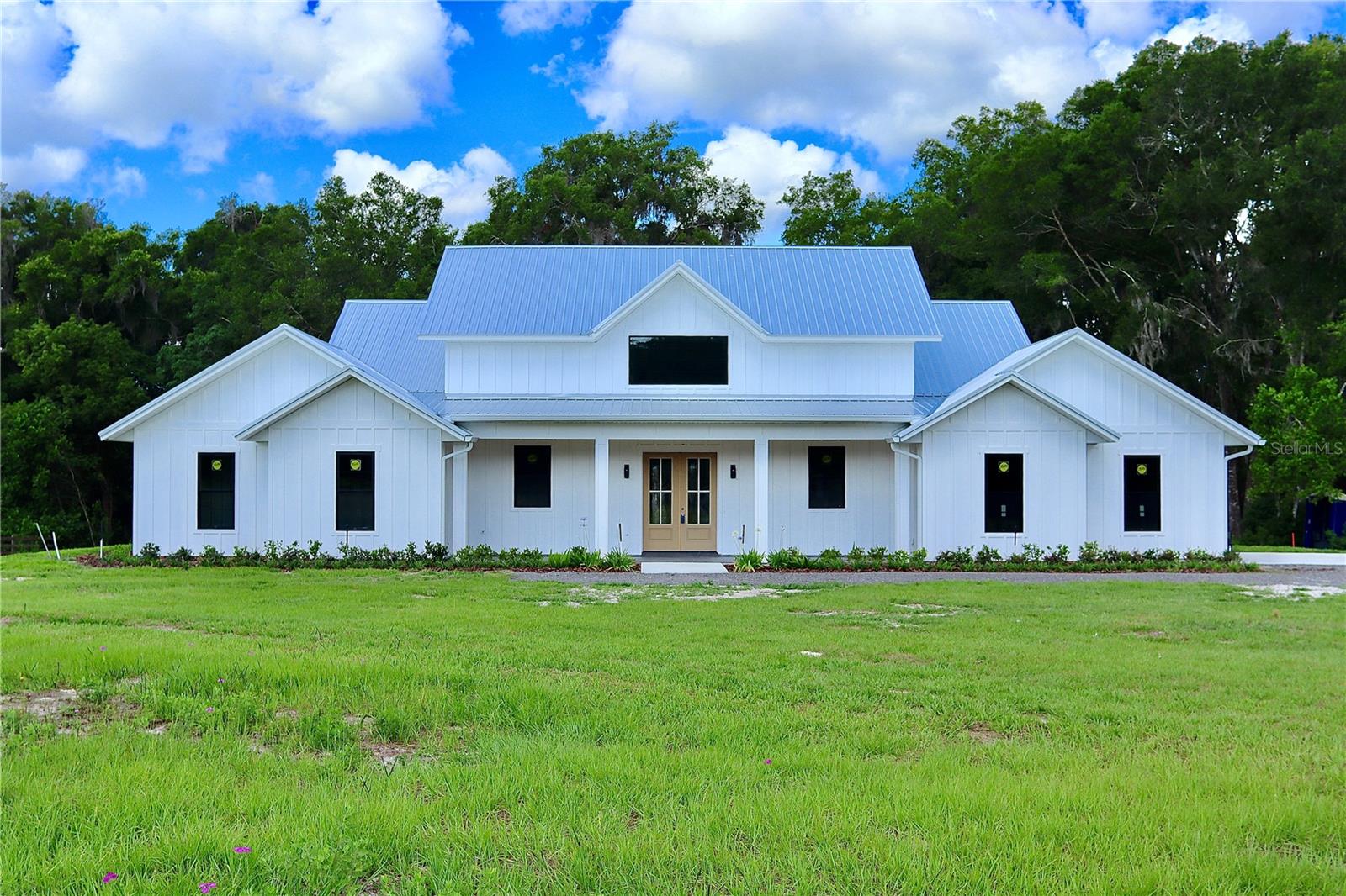 Under Construction. Project is almost complete, new listing photos coming soon! LUXURY NEW CONSTRUCTION ON 2.5 ACRES: NO HOA & A-3 ZONING!

Escape to your private oasis in highly-desirable DeLand! This brand-new, custom-built estate offers the rare combination of private country living on 2.5 ACRES with the convenience of being just minutes from Historic Downtown, Stetson University, and top-rated schools. Enjoy serene mornings surrounded by historic oaks and regular deer sightings—this is the best of both worlds! This spectacular 4-bedroom, 3.5-bath residence boasts 3,333 sq. ft. of living space (4,965 sq. ft. total under roof). Designed for modern luxury and entertaining, the massive, open-concept layout is dramatically enhanced by STUNNING VAULTED CEILINGS throughout the main living area, creating an incredible sense of light and scale.
The gourmet kitchen is a chef's dream, featuring a truly grand center island, two sinks, and a dedicated beverage center. The spacious, light-filled walk-in pantry includes a window overlooking the property. The kitchen flows seamlessly into the immense dining and entertainment area, which is perfect for large gatherings and showcases a stunning 12-foot built-in bar. The home offers exceptional sleeping arrangements, including a Luxurious Primary Suite featuring its own VAULTED CEILING and a spa-like bathroom with double vanity and an impressive double shower. A perfectly integrated walk-in closet connects directly to the laundry room for unmatched convenience. Guests will enjoy the Spacious Junior Suite with its own walk-in closet and beautiful attached full bathroom, alongside two additional large guest rooms that share a well-appointed guest bathroom.
Florida living is optimized with EXPANSIVE PORCH AREAS that provide plenty of space for outdoor dining, lounging, and fully enjoying the peaceful setting. Functionality is paramount, with a dedicated front-of-house office space for quiet work, and a utility wing featuring a large mudroom and coat closet leading to an extended 2-car garage with ample room for storage and bikes. Tucked away on a quiet road, enjoy only the sounds of nature, yet maintain quick access to all local amenities. With No HOA or deed restrictions here, you have the freedom to bring your boat, RV, or dreams!
Don't miss the opportunity to claim this magnificent property. Schedule your private hard-hat tour today!